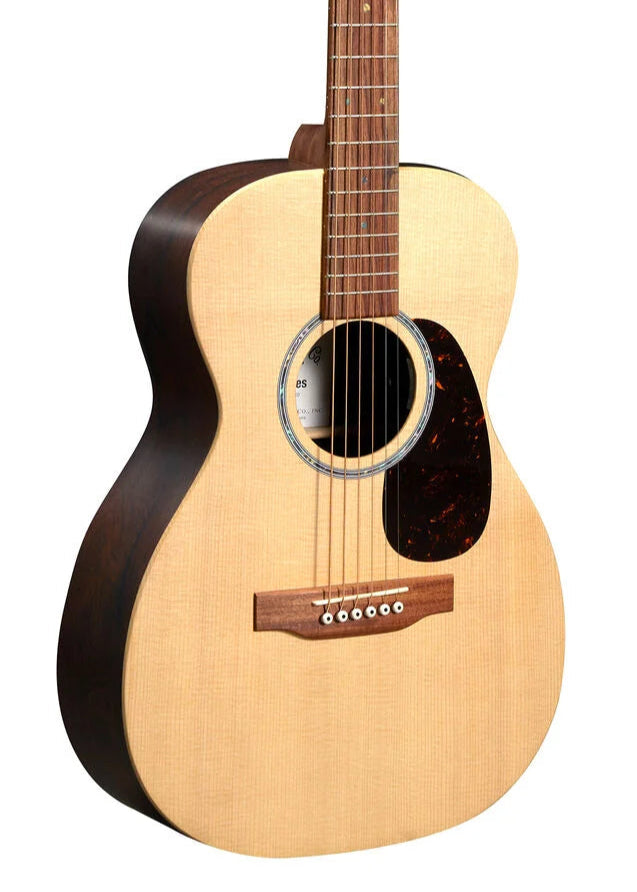 Light wood acoustic guitar with six strings, a dark pickguard, and a circular sound hole; sides and neck are darker wood.