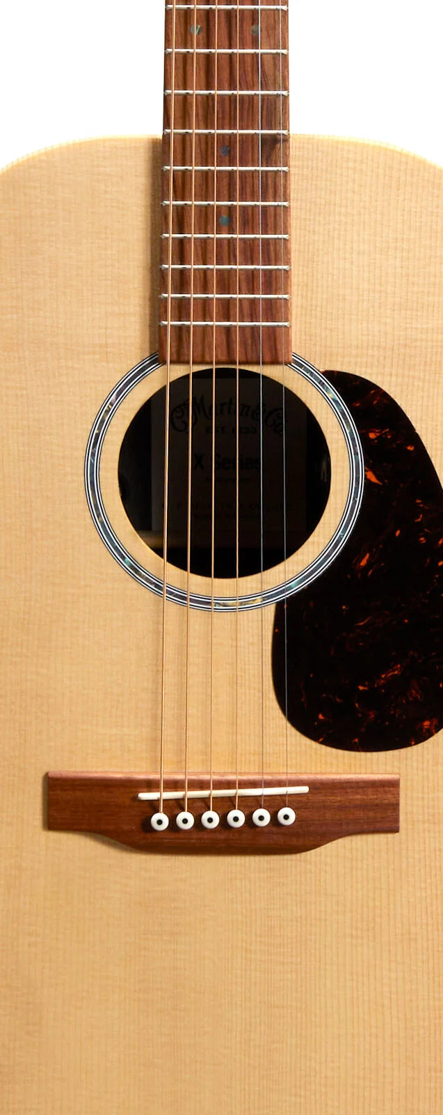 Light wood acoustic guitar body with six steel strings, a circular sound hole, dark pickguard, and rosewood bridge with white pegs.