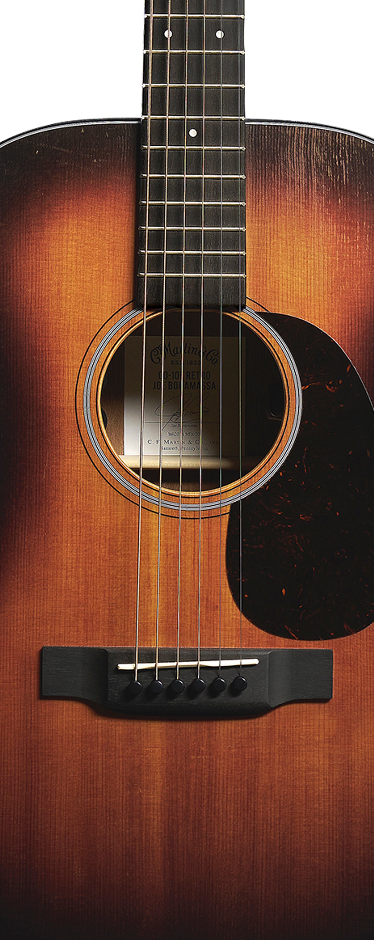 Guitare acoustique à six cordes avec finition sunburst, plaque de protection sombre près de la rosace et chevalet noir avec six chevilles.