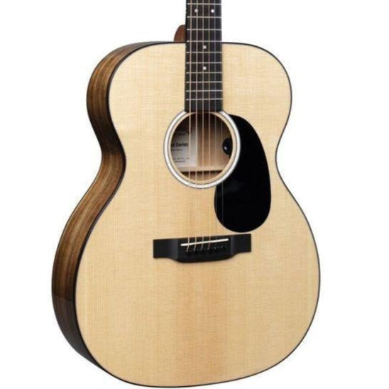 Acoustic guitar with a light wood top, dark sides, black pickguard, round sound hole, and six strings.