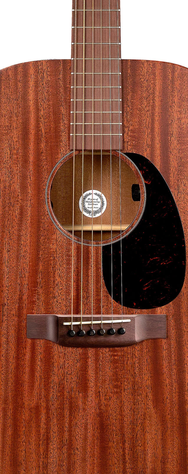 Acoustic guitar with a natural mahogany finish, six strings, dark oval pickguard, round sound hole, and wooden bridge with black pins.