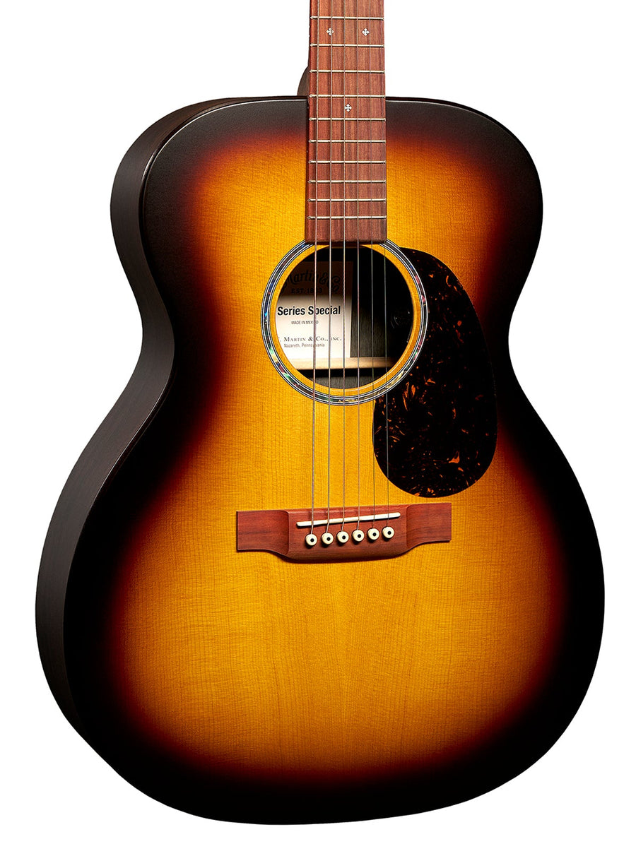 Guitare acoustique avec table en bois dégradé jaune à brun, six cordes, rosace cerclée et pickguard sombre sous les cordes.