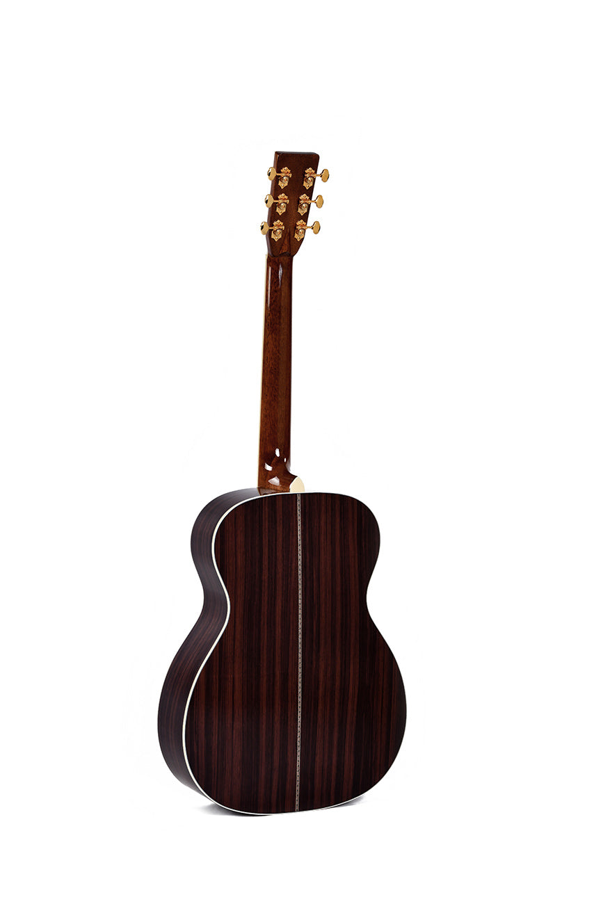 Acoustic guitar shown from the back, featuring dark wood with a central inlay stripe and gold tuning pegs on the headstock.