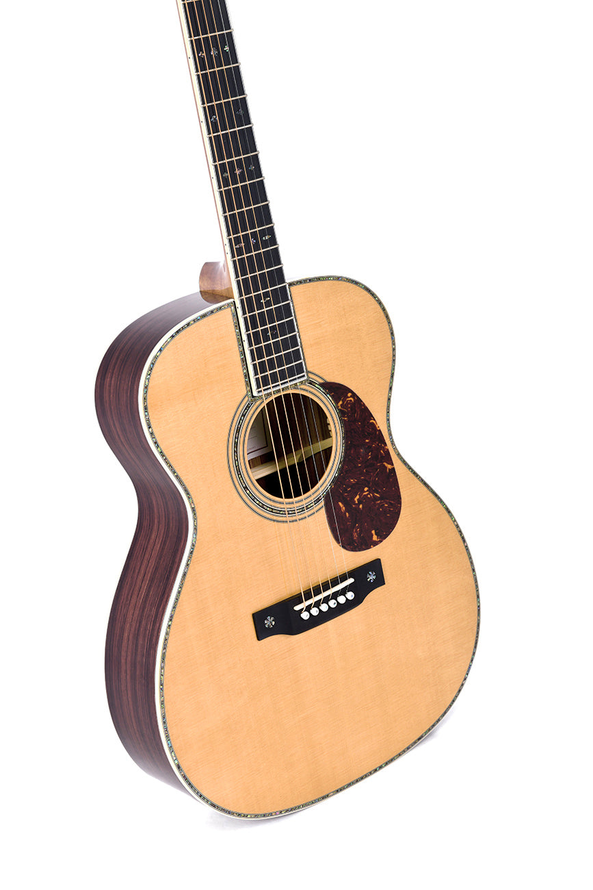Acoustic guitar with a light wood top, dark sides, abalone inlays around the edges, and a tortoiseshell-patterned pickguard below the sound hole.