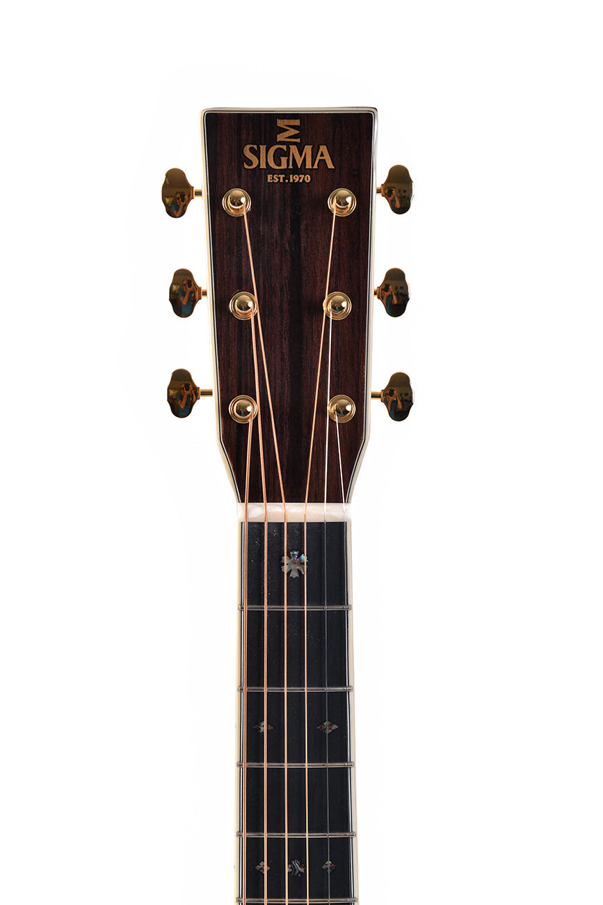 Sigma acoustic guitar headstock with six gold tuning pegs, dark wood finish, and "SIGMA EST. 1970" logo in gold lettering.