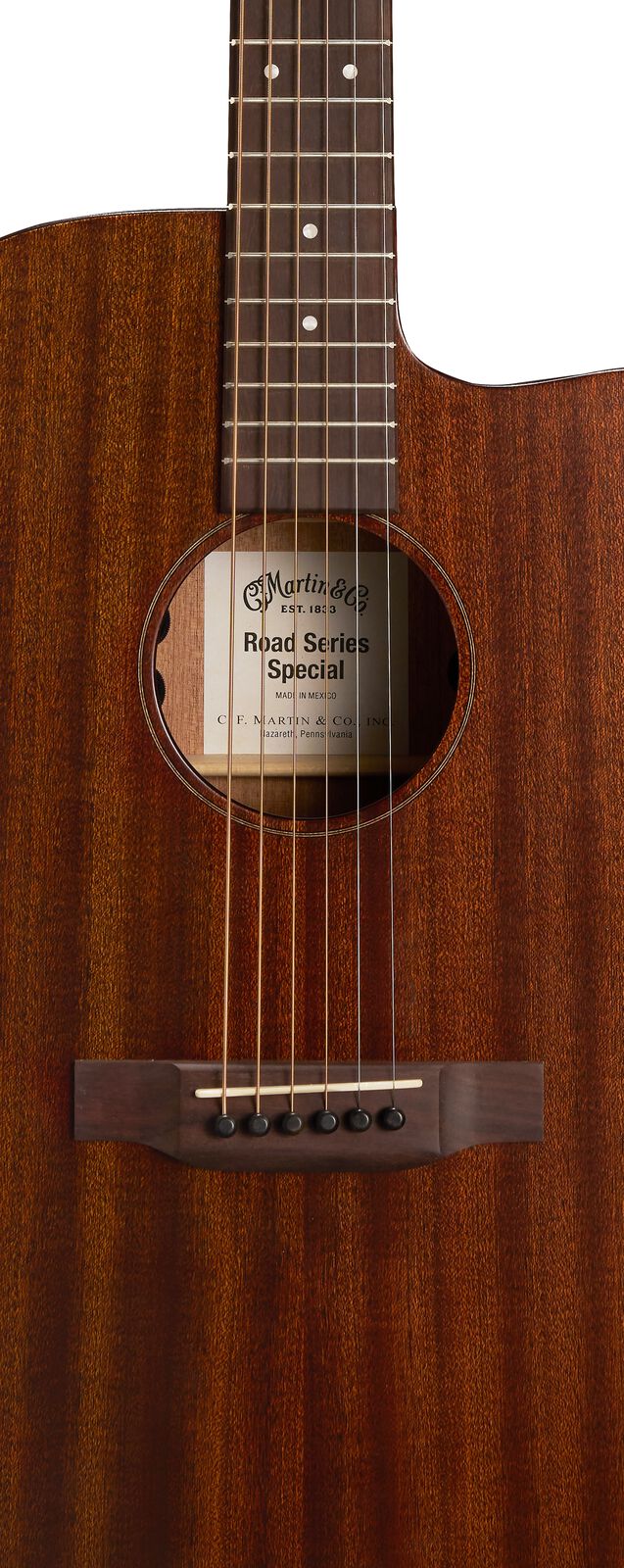 Rich brown acoustic guitar with six steel strings, a cutaway body, and a visible Martin & Co. Road Series Special label inside the sound hole.