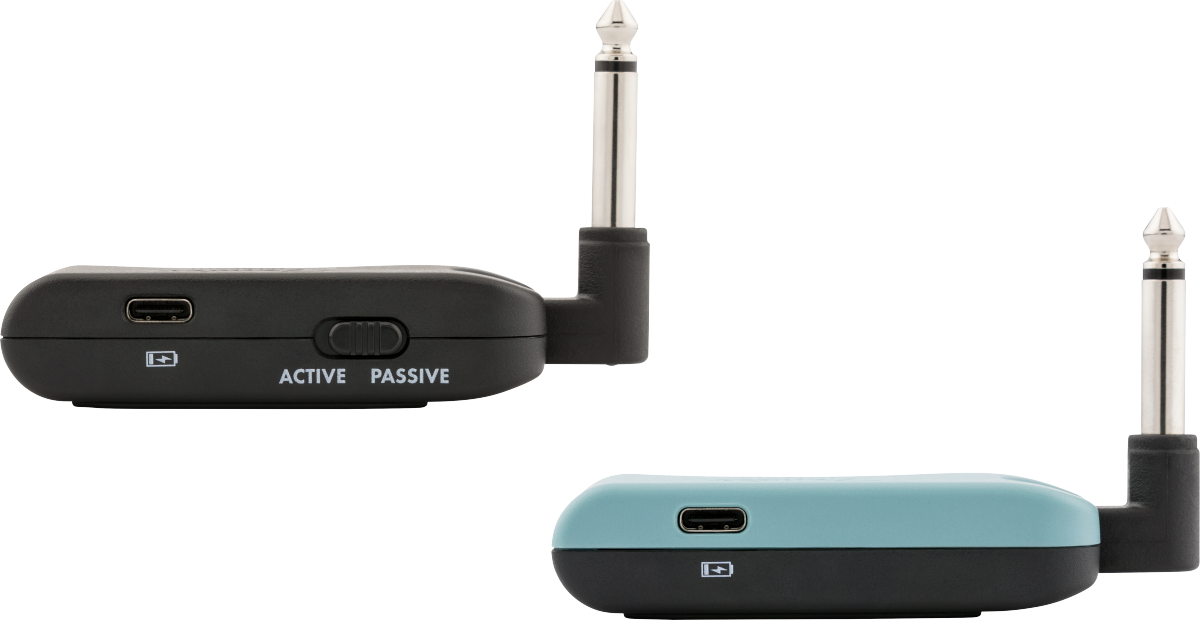 Two wireless audio transmitter accessories with 1/4-inch plugs, USB-C charging ports, and a switch labeled Active/Passive on the black unit.