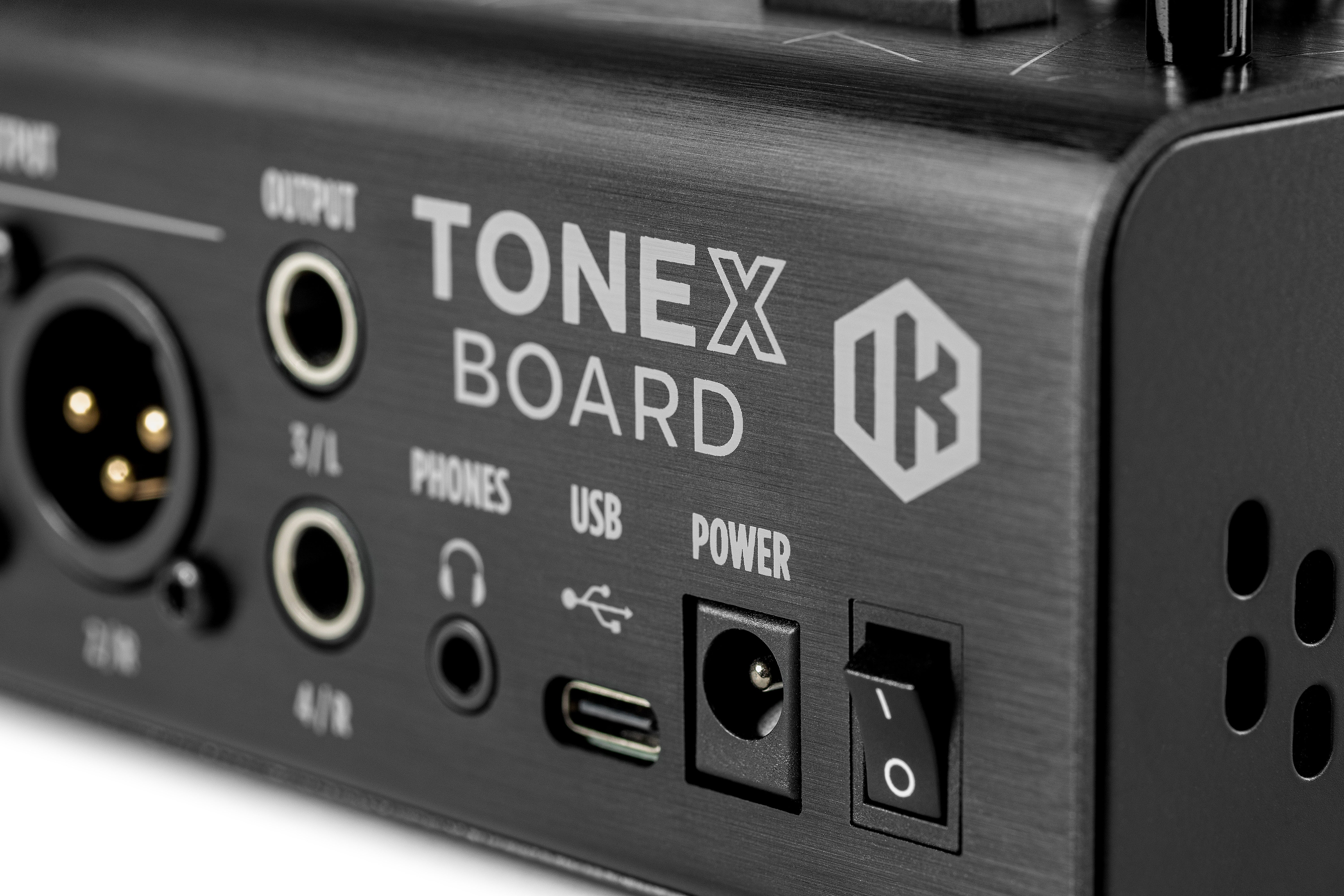 Black effects pedal labeled TONEX BOARD with XLR, 1/4-inch output, headphone, USB-C, power input, and a power switch visible on the side.