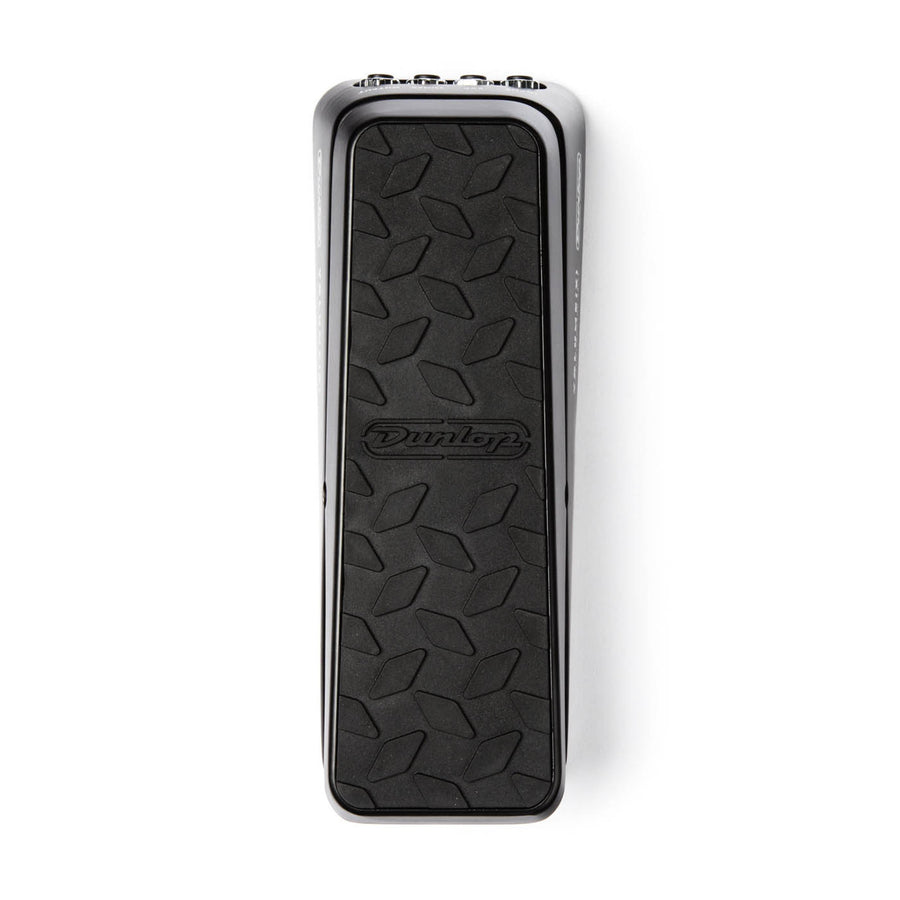 Pédale d'effet guitare rectangulaire, surface noire antidérapante avec motif losange et logo Dunlop au centre, bords métalliques chromés.