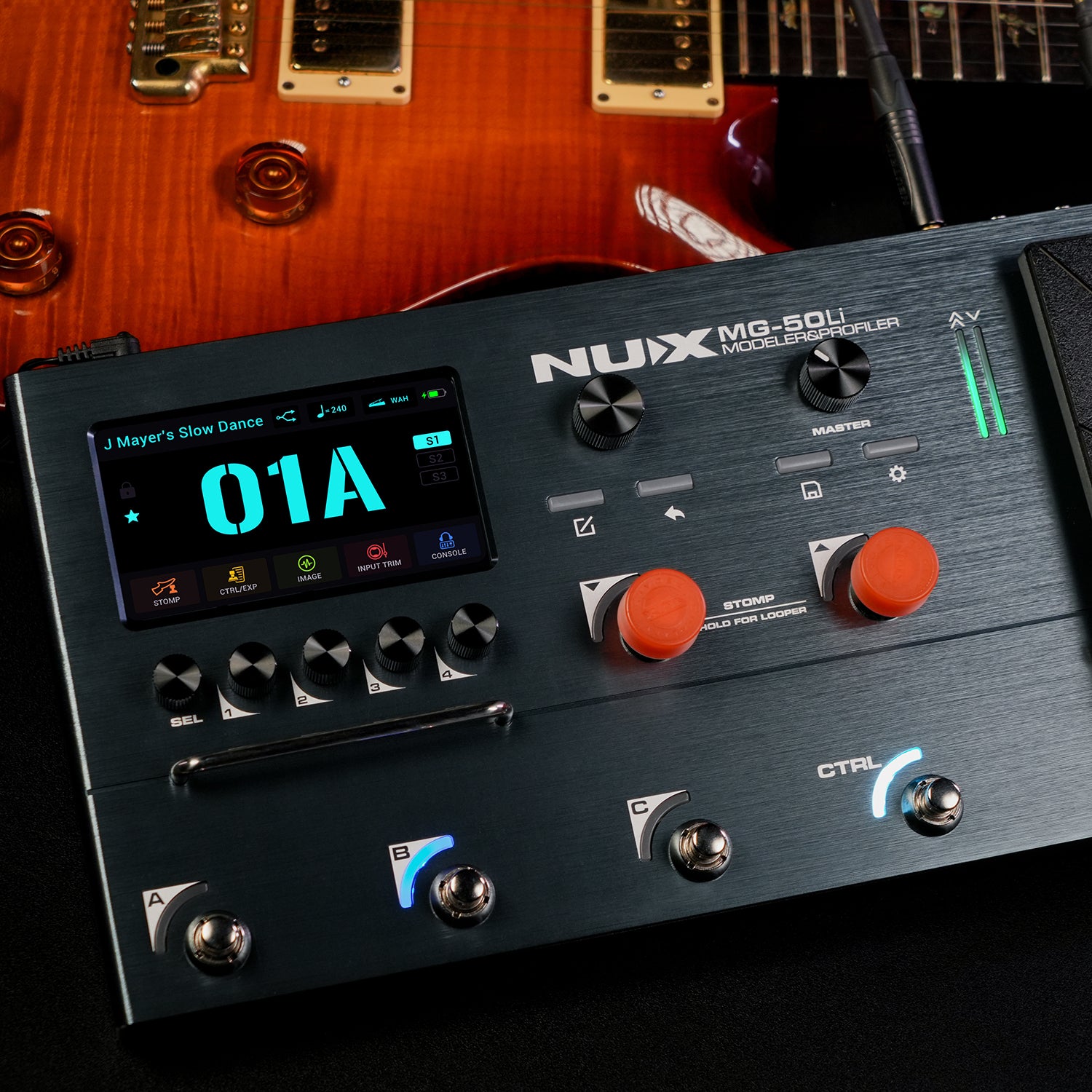 Pédalier multi-effets NUX MG-50Li noir avec écran couleur, plusieurs boutons, trois footswitchs lumineux, une guitare électrique visible en arrière-plan.
