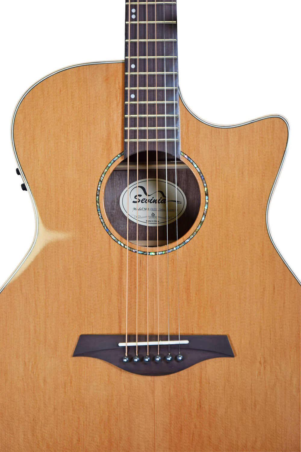 Light wood acoustic guitar with a cutaway body, six strings, abalone rosette, dark wood bridge, and visible label inside the soundhole.