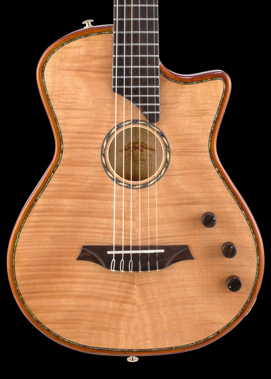 Guitare acoustique à pan coupé, table en bois clair avec motifs ondulés, trois boutons noirs et rosace cerclée de motifs colorés autour de la bouche.