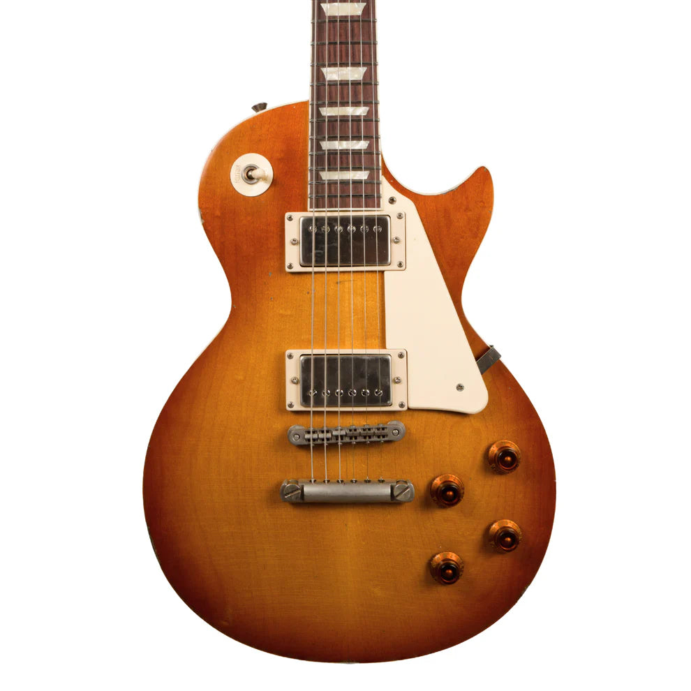 Sunburst electric guitar with a single cutaway, two humbucker pickups, four amber control knobs, and a cream-colored pickguard.