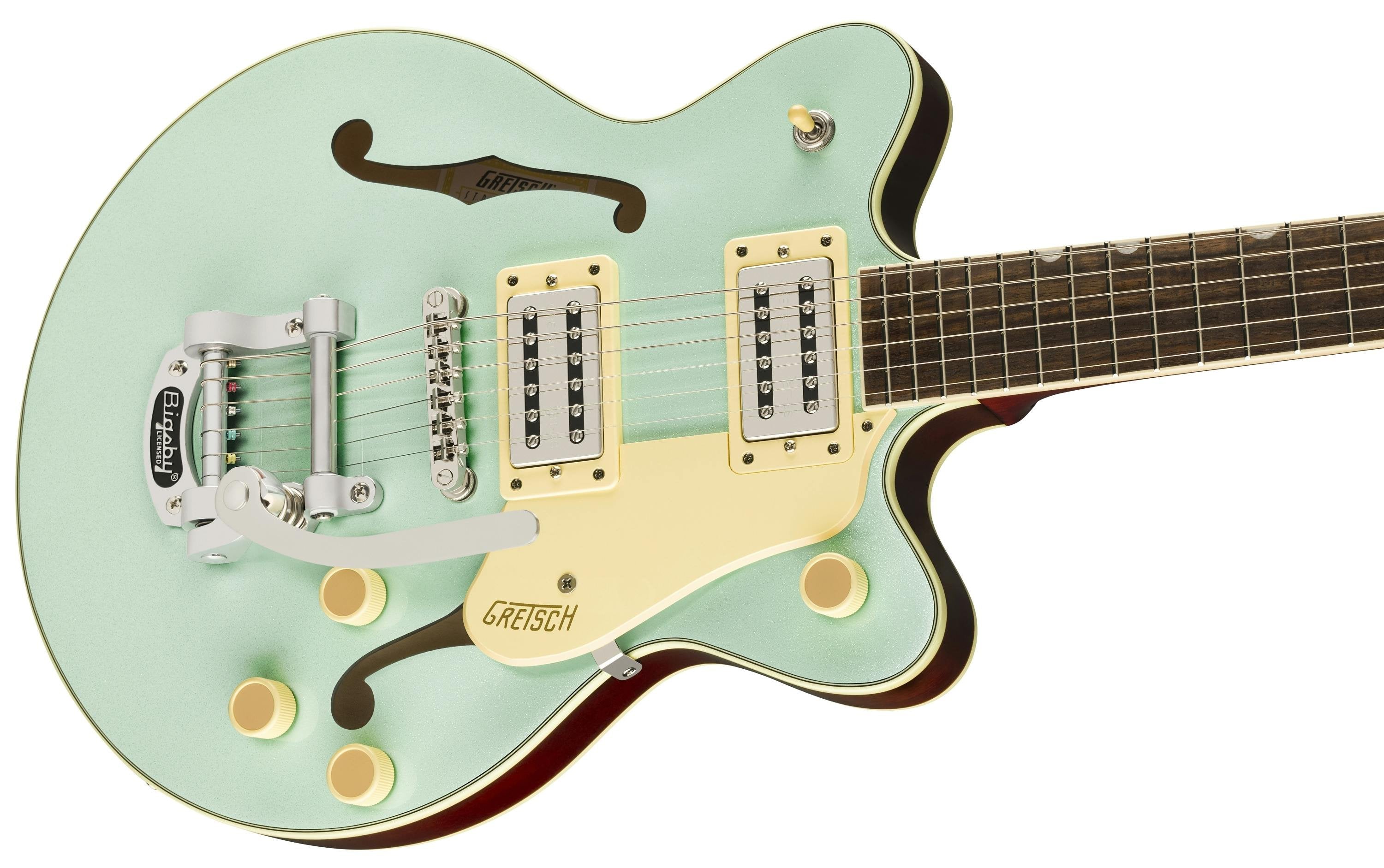 Mint green electric guitar with cream knobs, yellow pickguard, two rectangular pickups, f-holes, vibrato tailpiece, and dark wood neck.