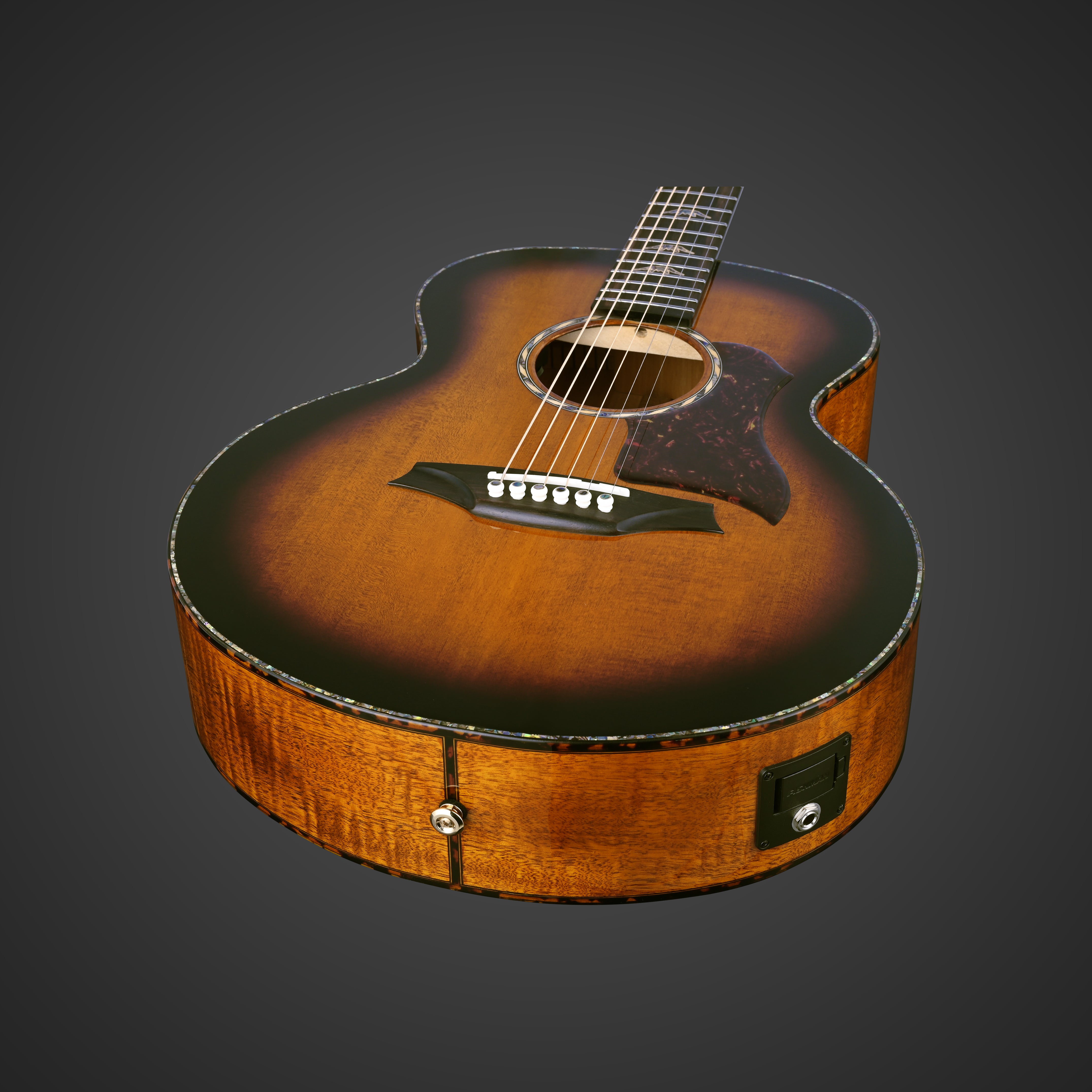 Dark sunburst acoustic guitar with six strings, a tortoiseshell pickguard, abalone trim, and electronic input jack on the side.