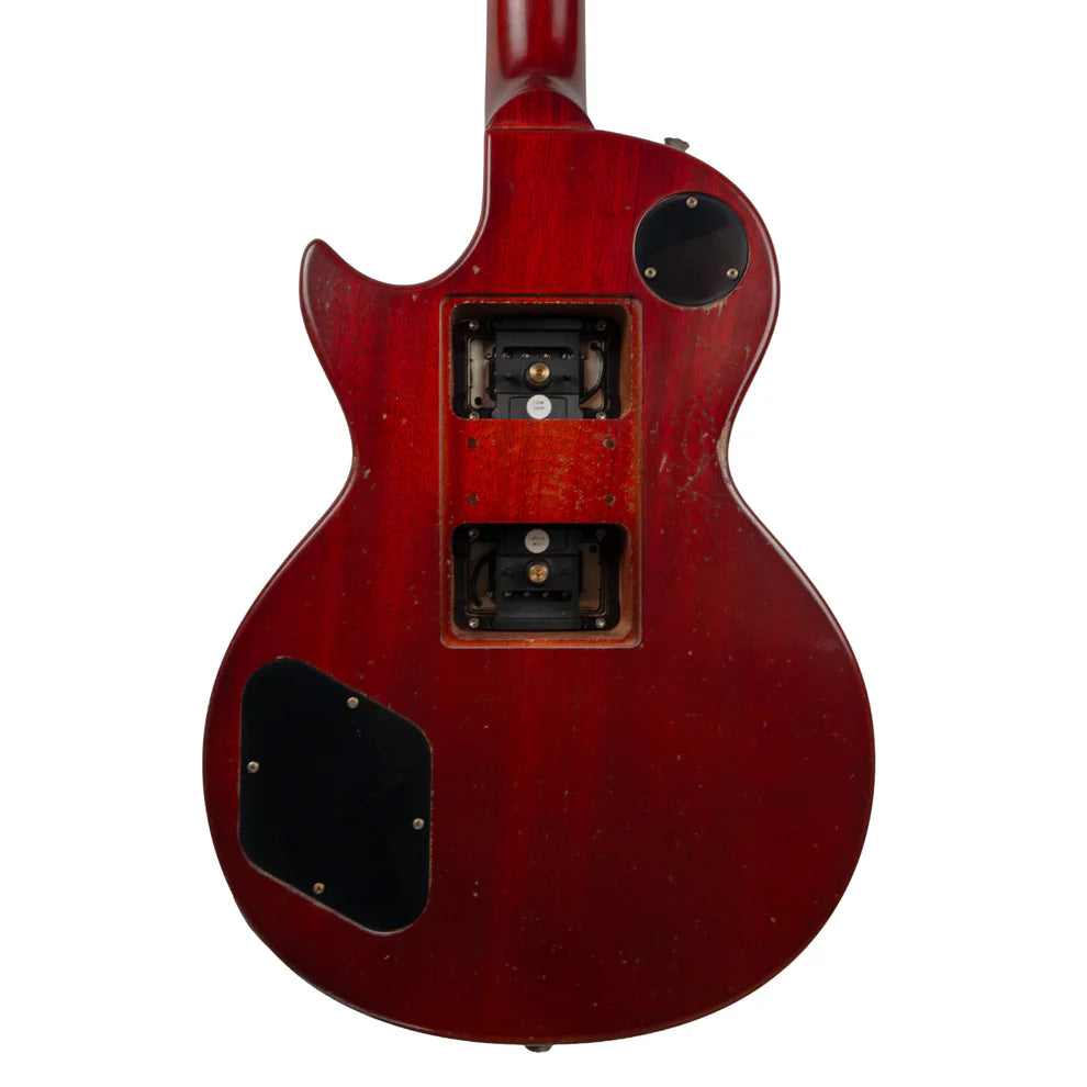 Back of a red electric guitar showing three open control cavities with visible electronics and some scratches on the wood finish.