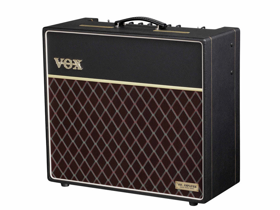 Black VOX guitar amplifier with a gold logo, carrying handle, and a front panel featuring a maroon diamond-patterned grille.