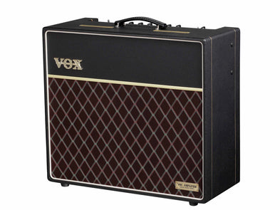 Black VOX guitar amplifier with a gold logo, carrying handle, and a front panel featuring a maroon diamond-patterned grille.