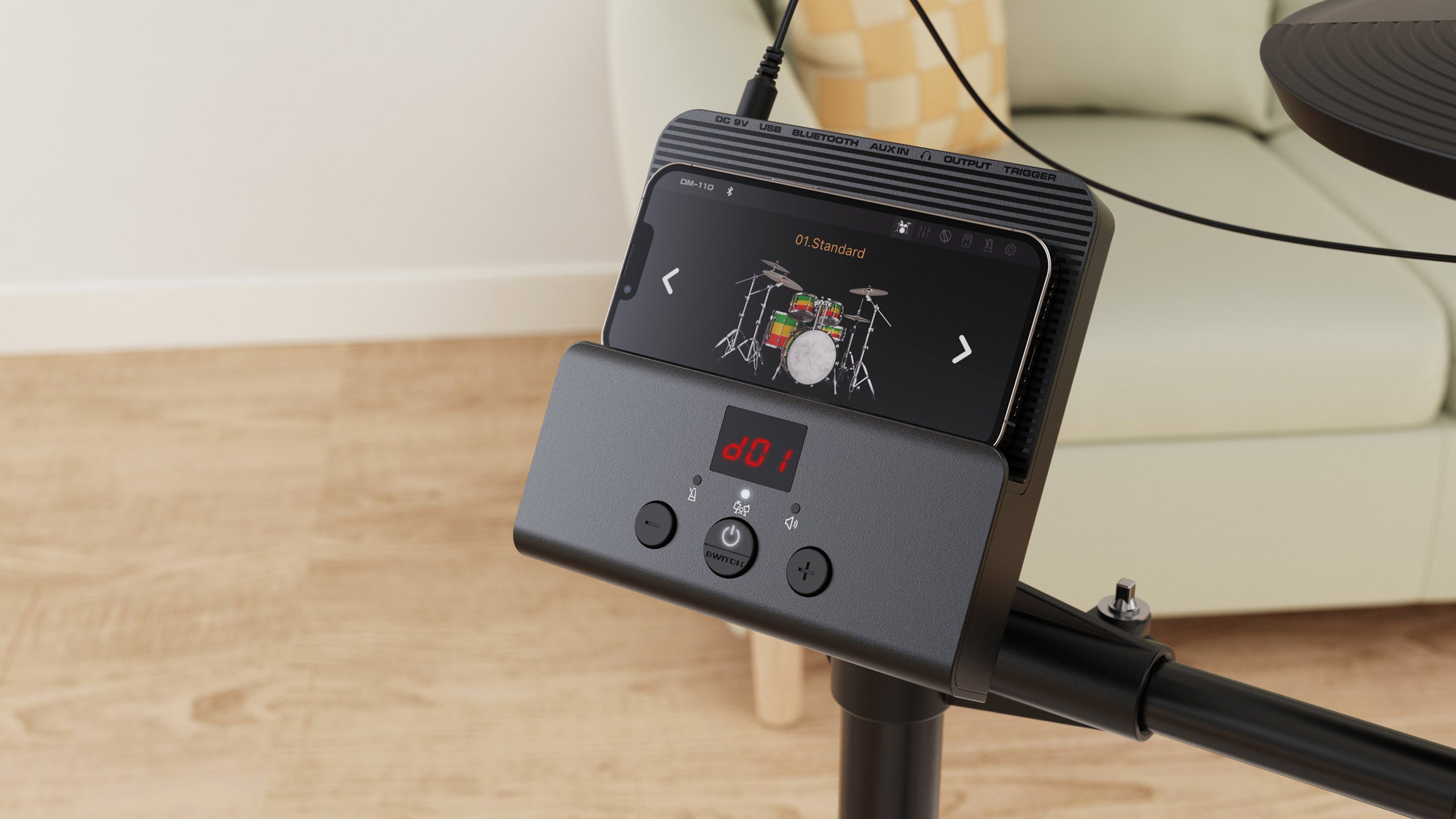 Electronic drums control module with a digital display and buttons, holding a smartphone showing a drum kit setup screen.