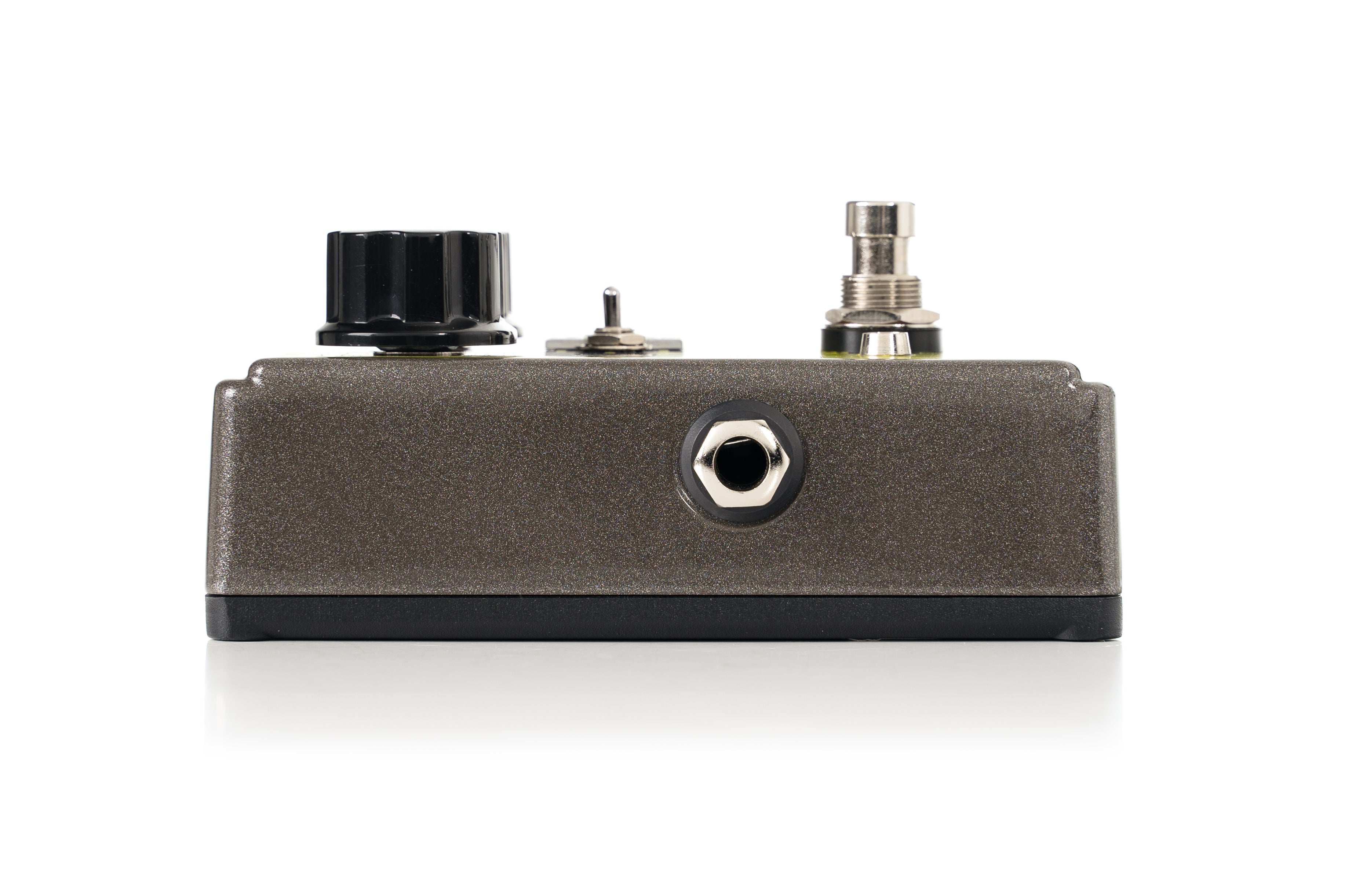 A metallic FX pedal with a large black knob, small toggle switch, footswitch, and a single audio jack on its front panel.