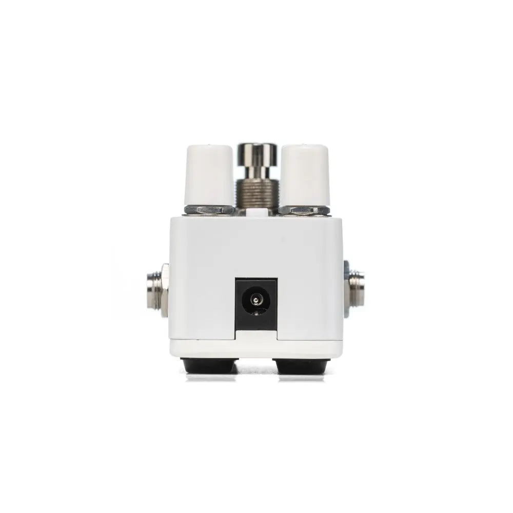 Compact white FX pedal with two white control knobs, a metal footswitch on top, side jacks, and a central power input on the front.