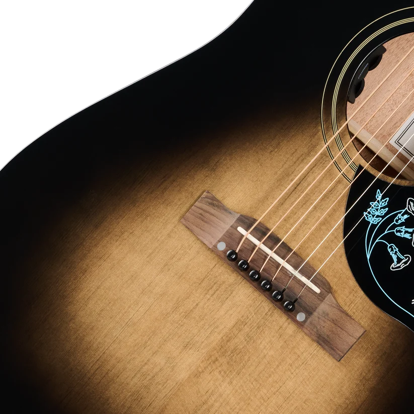 Sunburst-finish acoustic guitar body with six strings, wooden bridge, and a black pickguard featuring blue floral and bird designs.