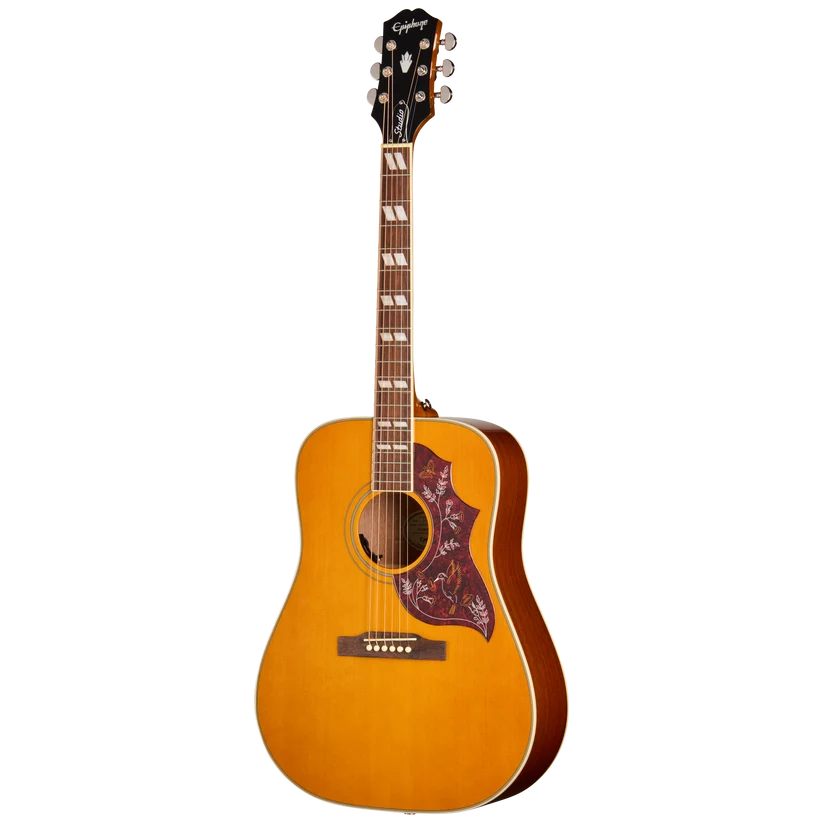 Guitare acoustique en bois clair avec pickguard en forme d’aile décoré de motifs floraux colorés et six cordes.