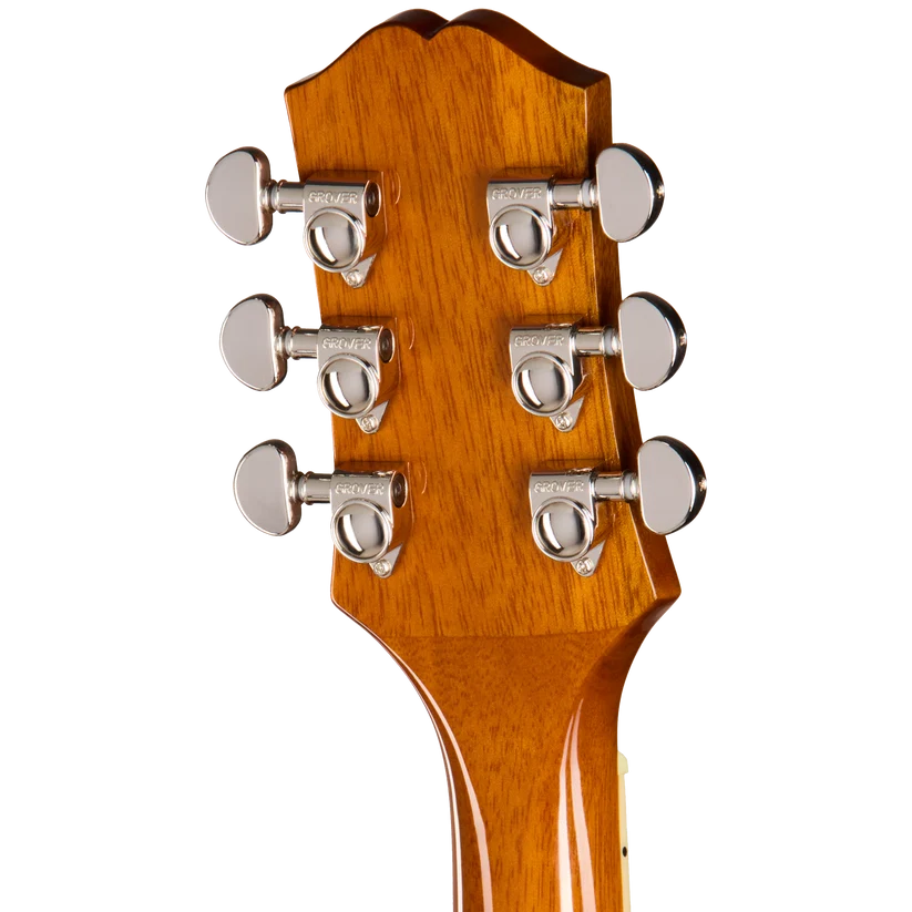 Six mécaniques chromées sont alignées par trois de chaque côté de la tête en bois verni d’une guitare acoustique.