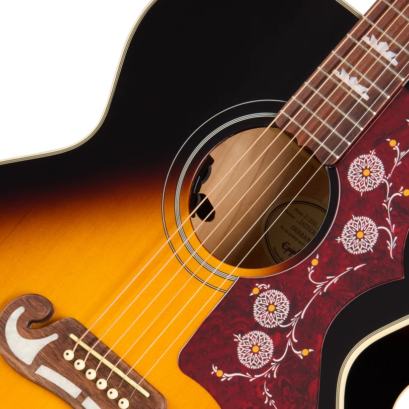 Acoustic guitar with a sunburst finish, decorative red pickguard featuring white floral inlays, and pearl inlays on the fretboard.