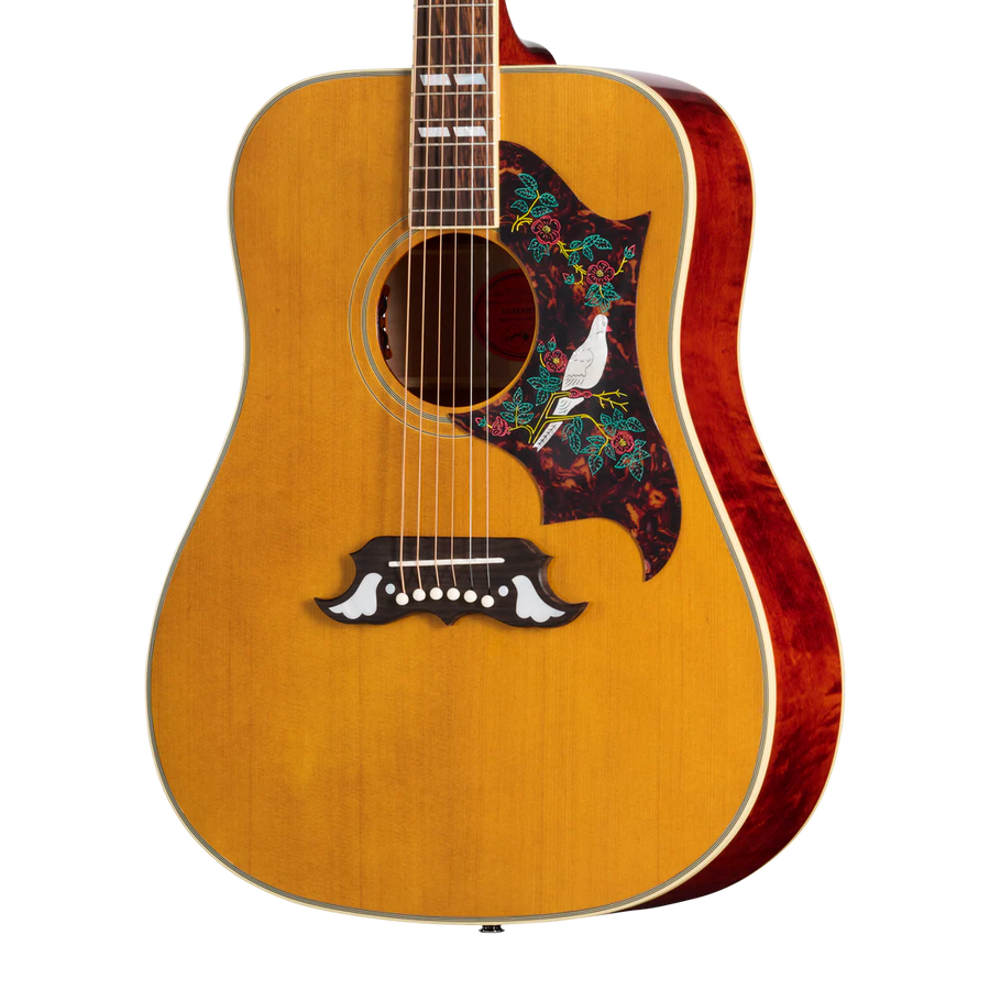 Acoustic guitar with a natural wood finish, floral pickguard featuring a white dove, and decorative white inlays on the bridge.