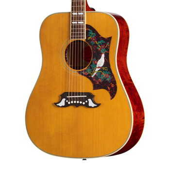 Acoustic guitar with a natural wood finish, floral pickguard featuring a white dove, and decorative white inlays on the bridge.