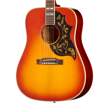 Sunburst acoustic guitar with a black pickguard featuring gold floral and bird designs, white binding, and six strings.