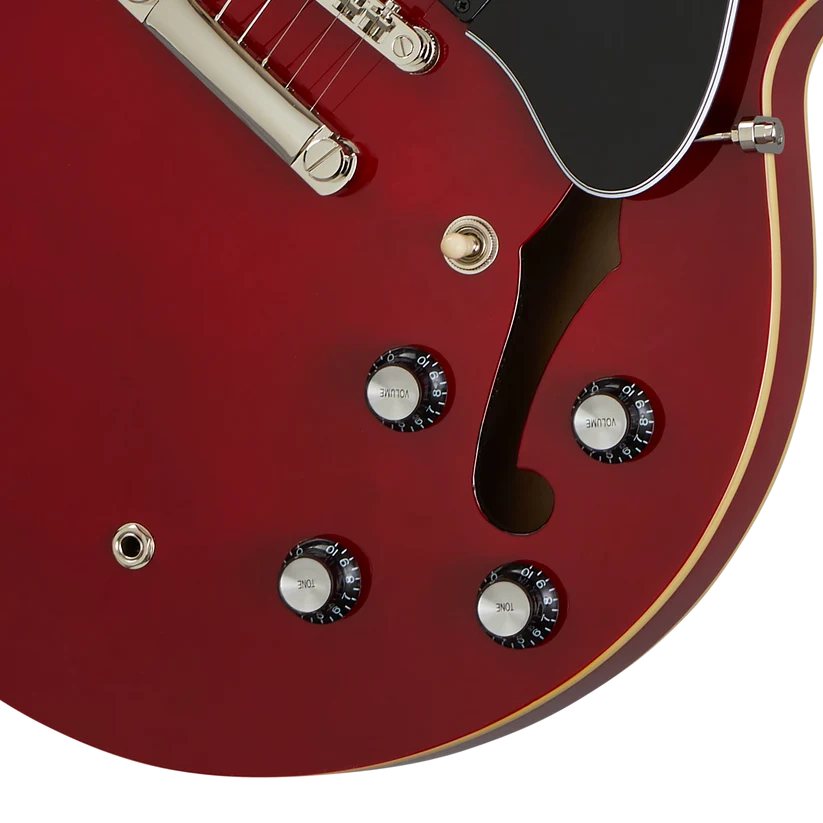 Red semi-hollow electric guitar with four black control knobs, gold hardware, single f-hole, black pickguard, and cream binding along the edge.