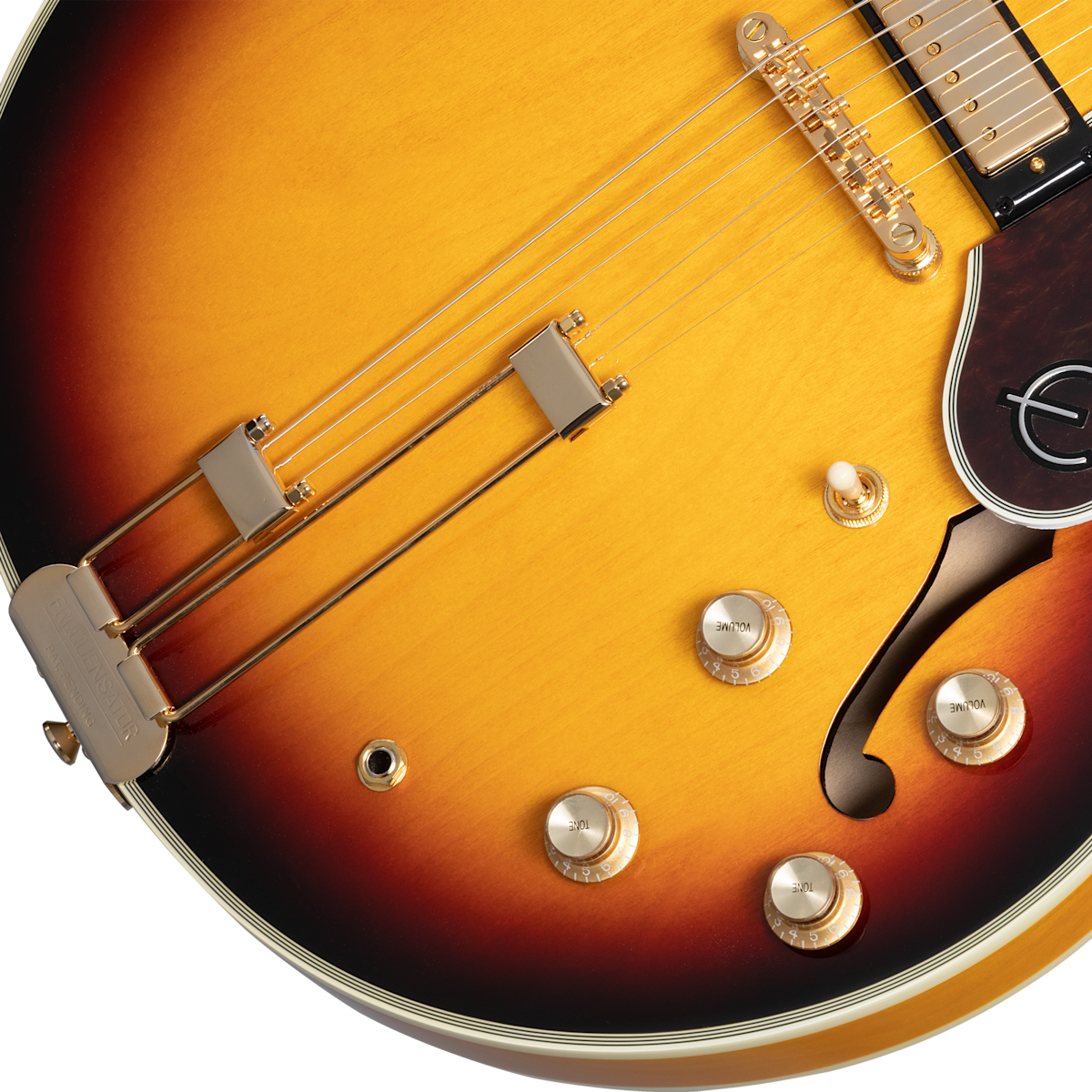 Sunburst electric guitar body with gold knobs, a dark pickguard, f-hole, and metal tailpiece; gradient finish from yellow to brown edges.