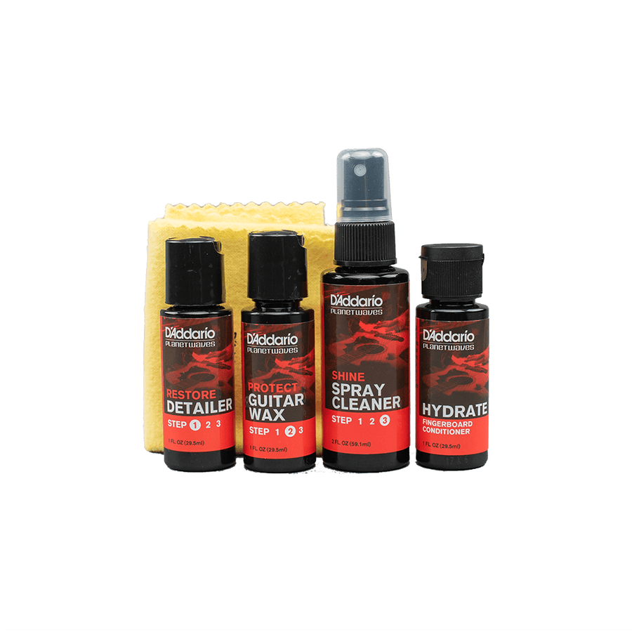 Four D'Addario guitar care bottles—detailer, wax, spray cleaner, hydrator—are lined up with a yellow cleaning cloth behind them.