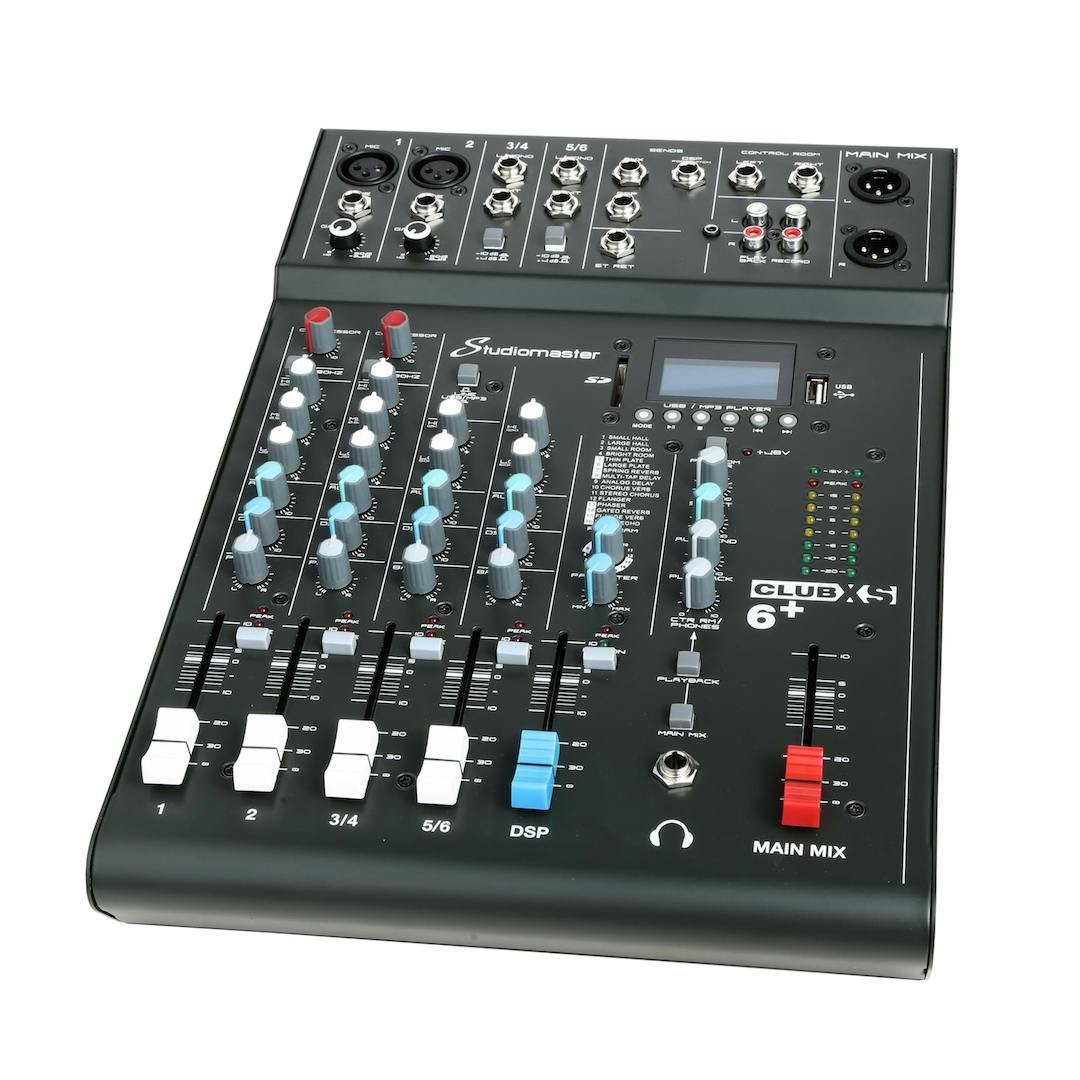 Studiomaster CLUBXS 6+ audio mixer with multiple faders, knobs, input jacks, output ports, a small display, and a main mix level meter.
