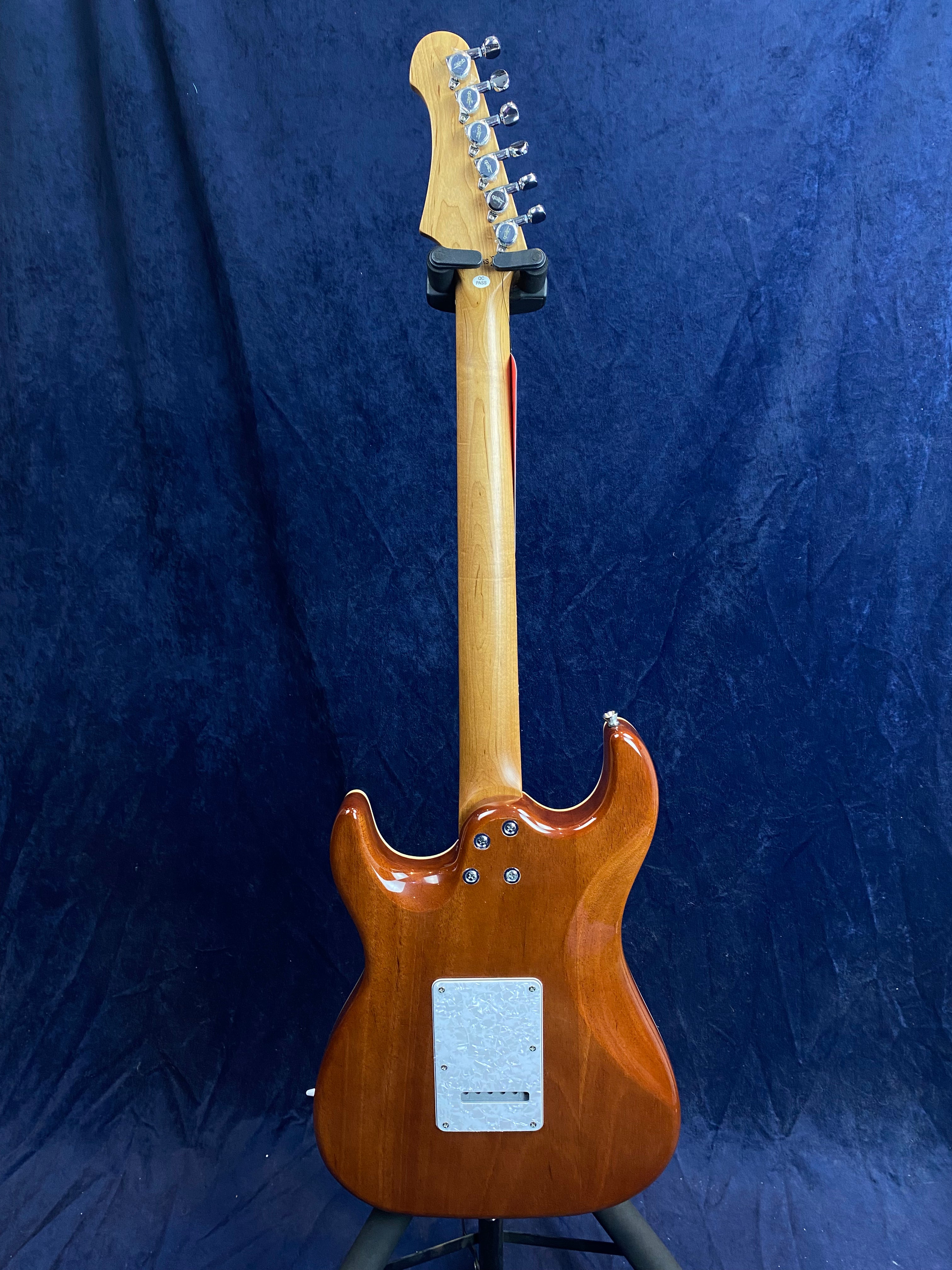 Electric guitar viewed from the back, showing a glossy brown wooden body, light maple neck, chrome tuners, and a white backplate.
