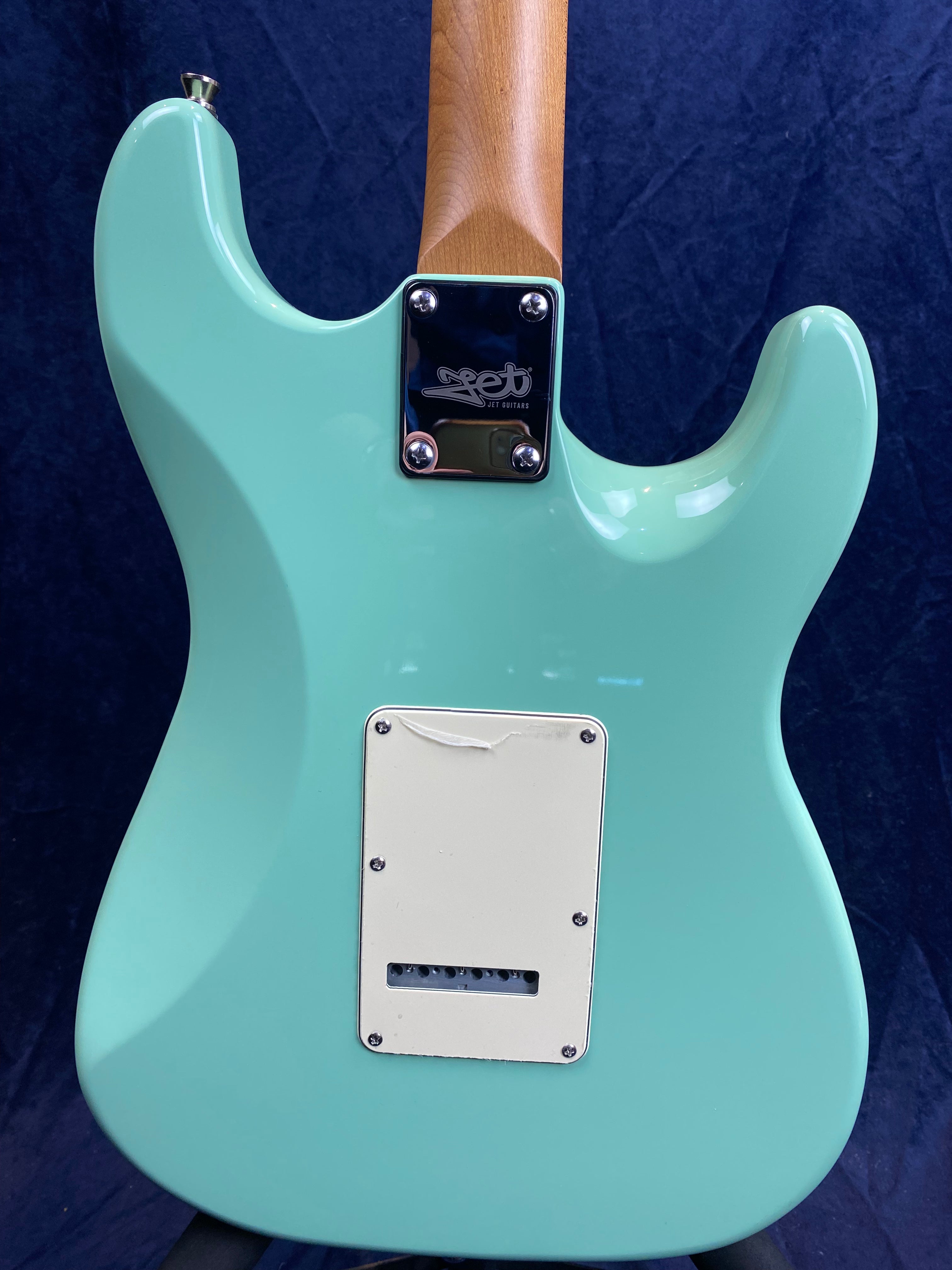 Aqua blue electric guitar back with a light wood neck, white backplate, and metal neck plate engraved with "SET GUITARS" logo.