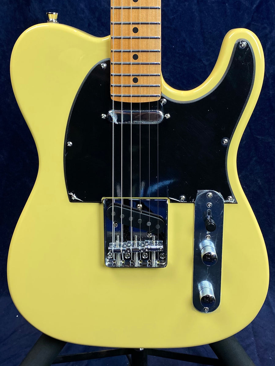 Yellow electric guitar with black pickguard, chrome bridge and controls, and a light wood neck with black fret markers. Classic single-cutaway shape.