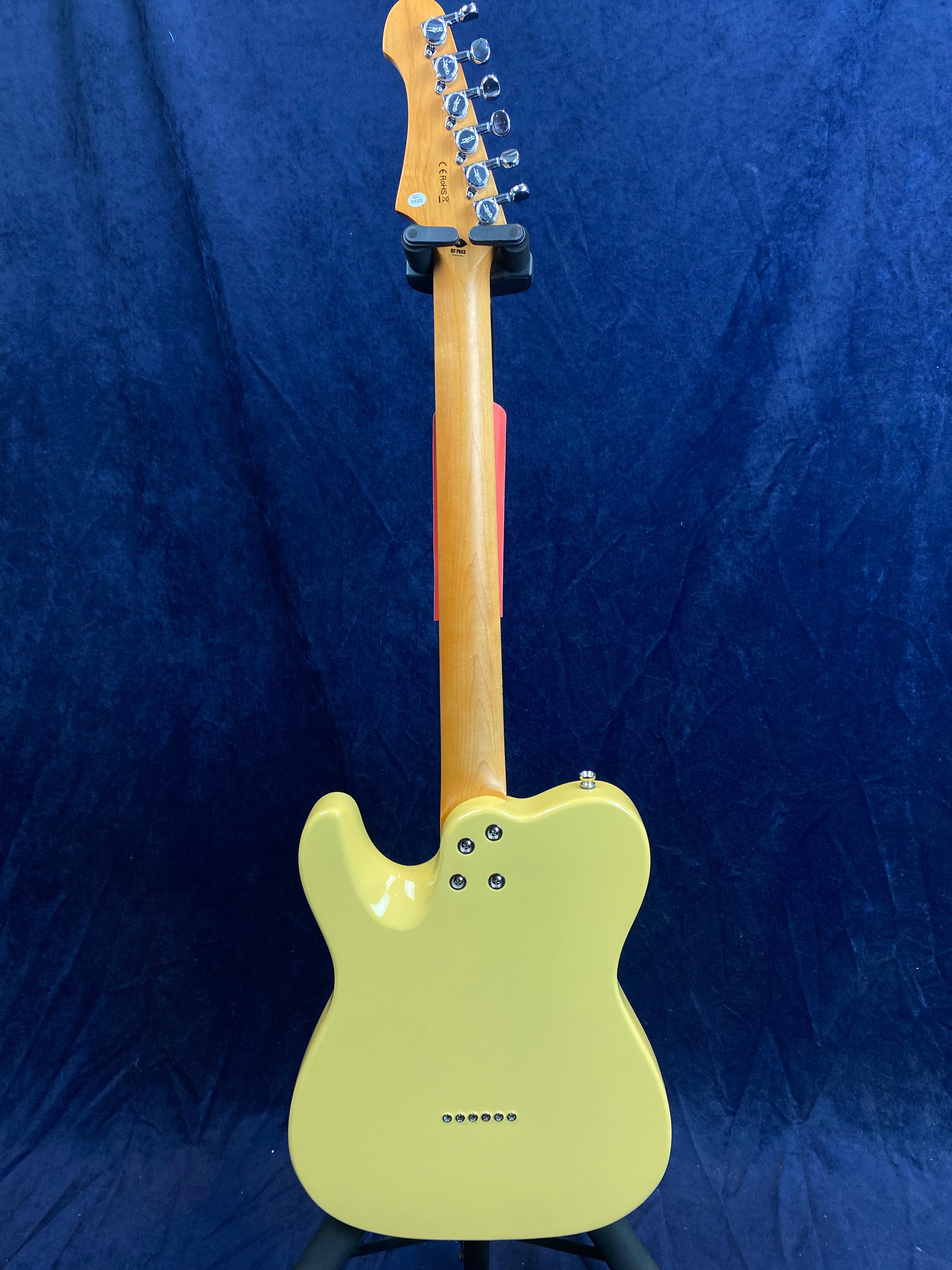 Yellow electric guitar shown from the back, with a natural wood neck, silver tuning pegs, and visible screw mounts on the body.
