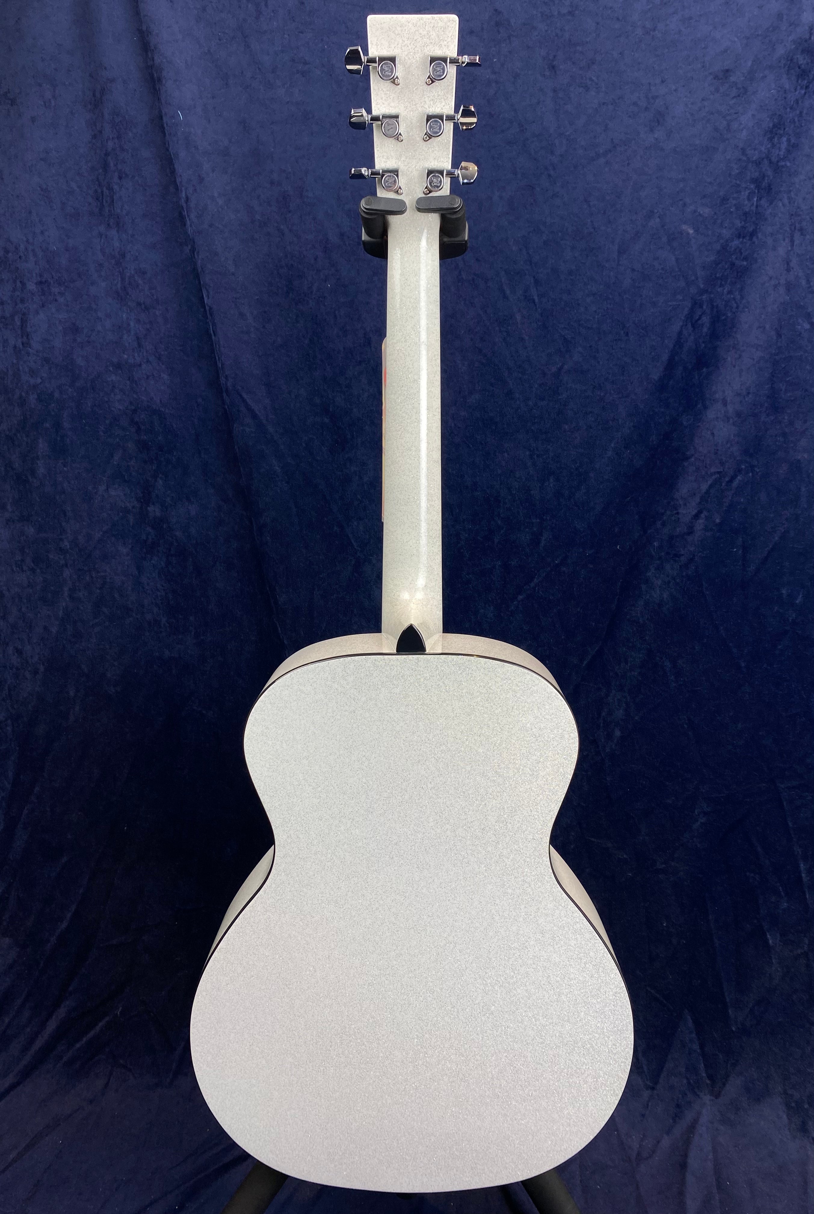 Acoustic guitar shown from the back with a smooth, light gray finish and six chrome tuning pegs on the headstock.