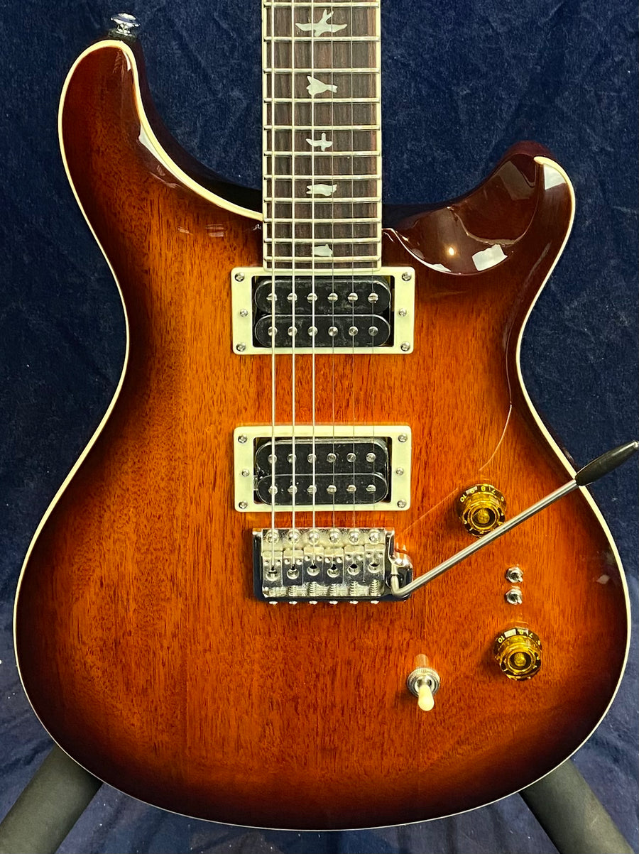 Sunburst electric guitar with two humbucker pickups, whammy bar, three control knobs, and bird-shaped fretboard inlays.