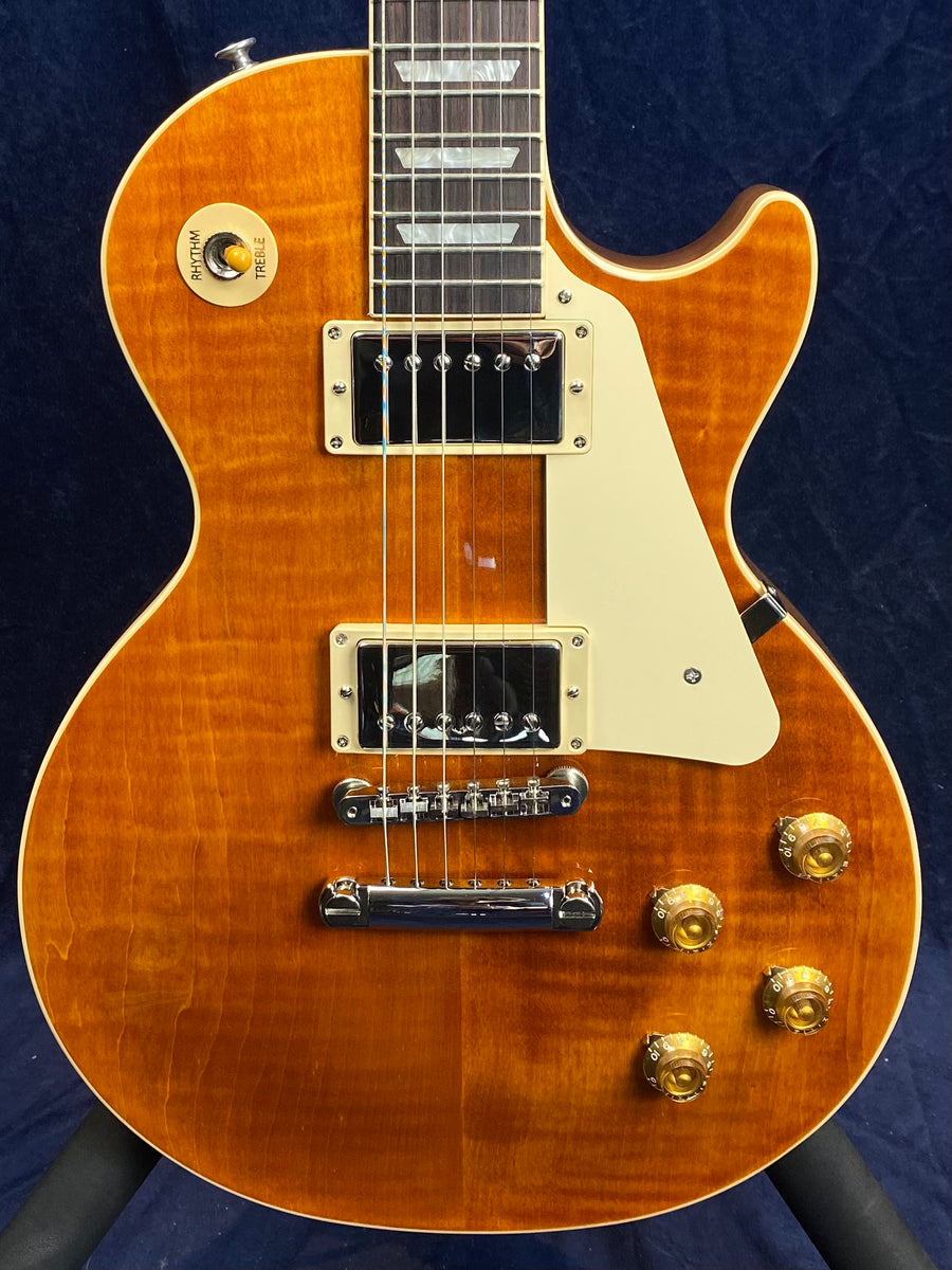 Sunburst electric guitar with cream pickguard, four gold control knobs, two chrome pickups, and a toggle switch labeled rhythm and treble.