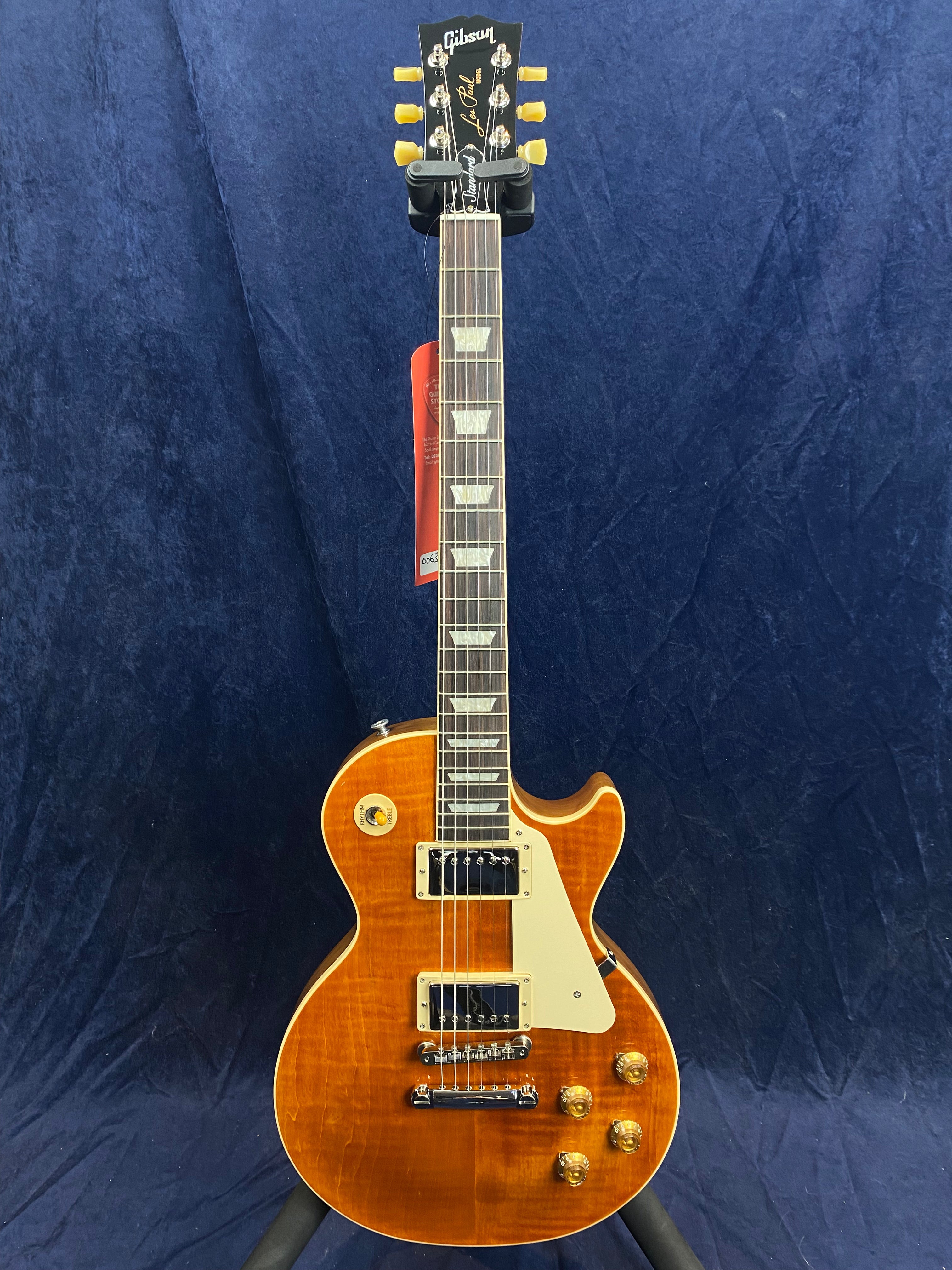 Sunburst finish electric guitar with a single cutaway, cream pickguard, four gold control knobs, and dual silver humbucker pickups.