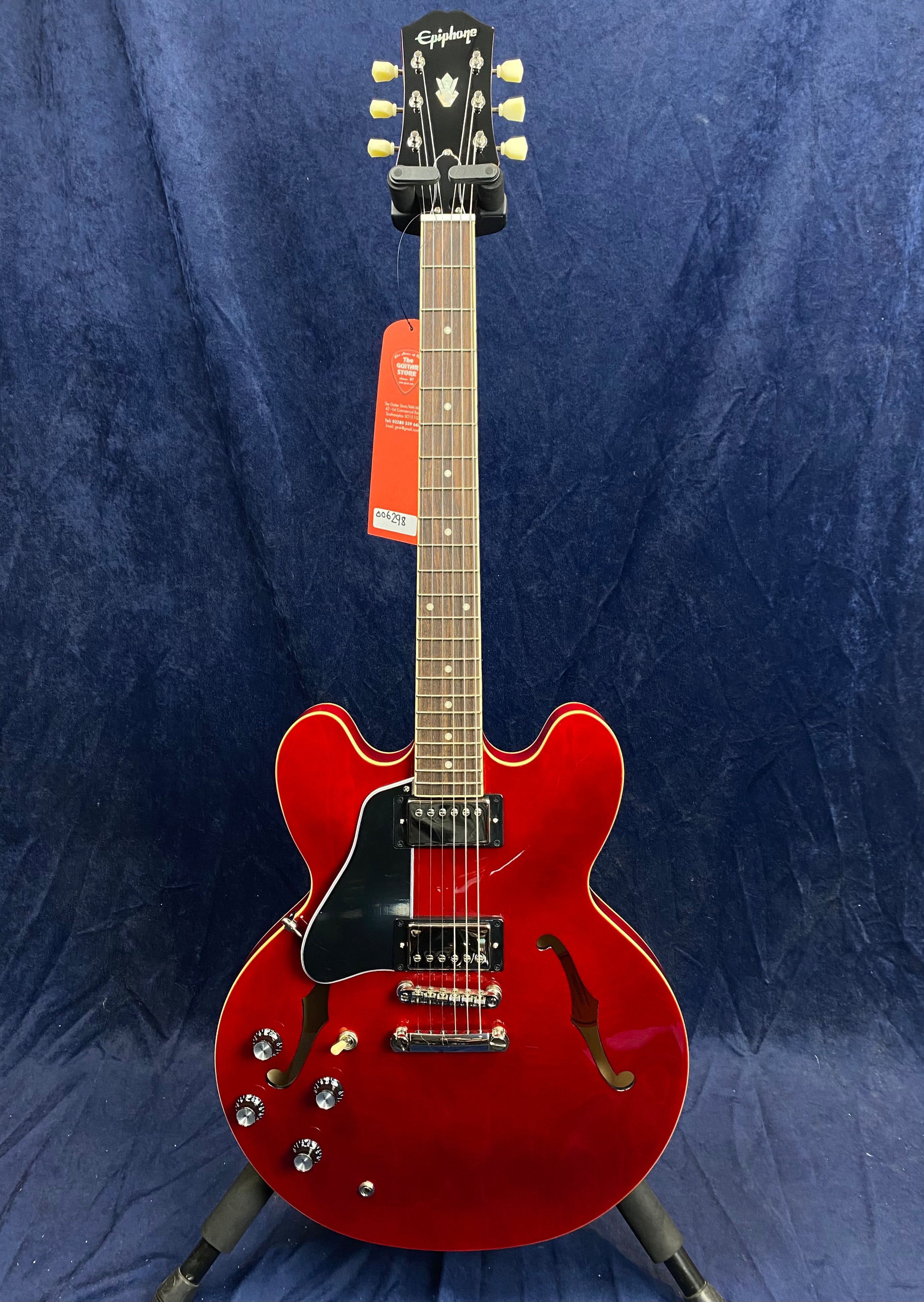 Red semi-hollow body electric guitar with double cutaway, two humbucker pickups, four control knobs, and a black pickguard.