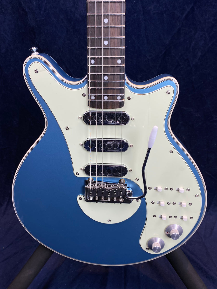 Blue electric guitar with a white pickguard, three black single-coil pickups, twelve slider switches, two knobs, and a chrome tremolo arm.