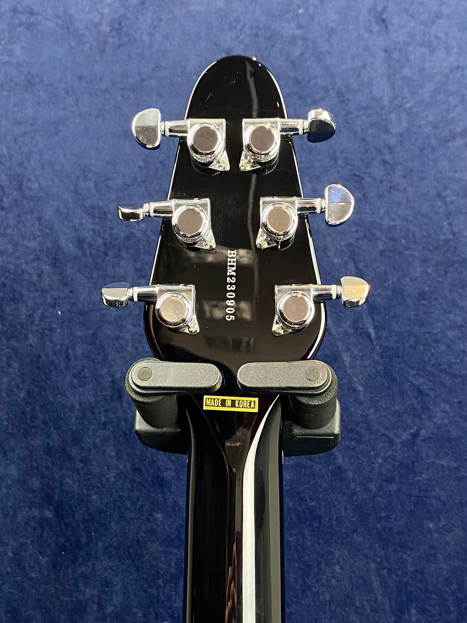 Back of an electric guitar headstock with six chrome tuners, serial number BHM239005, and a "Made in Korea" sticker on the neck.