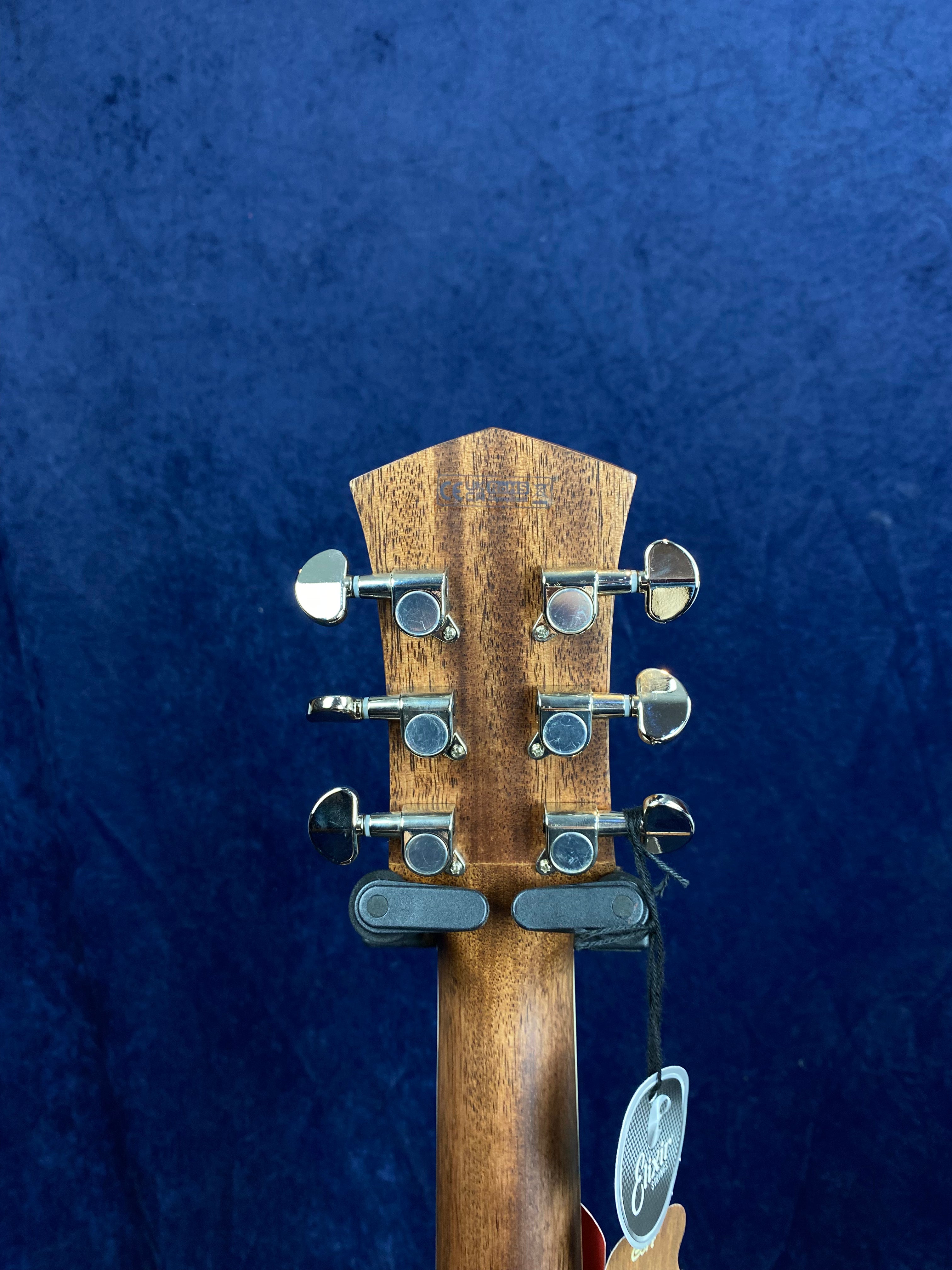 Six chrome tuning pegs on the back of a wooden acoustic guitar headstock, with a product tag hanging from the headstock against a blue background.