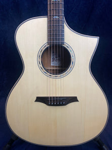 Light wood acoustic guitar with a single cutaway, dark wood bridge, decorative soundhole ring, and abalone bird inlays on the fretboard.
