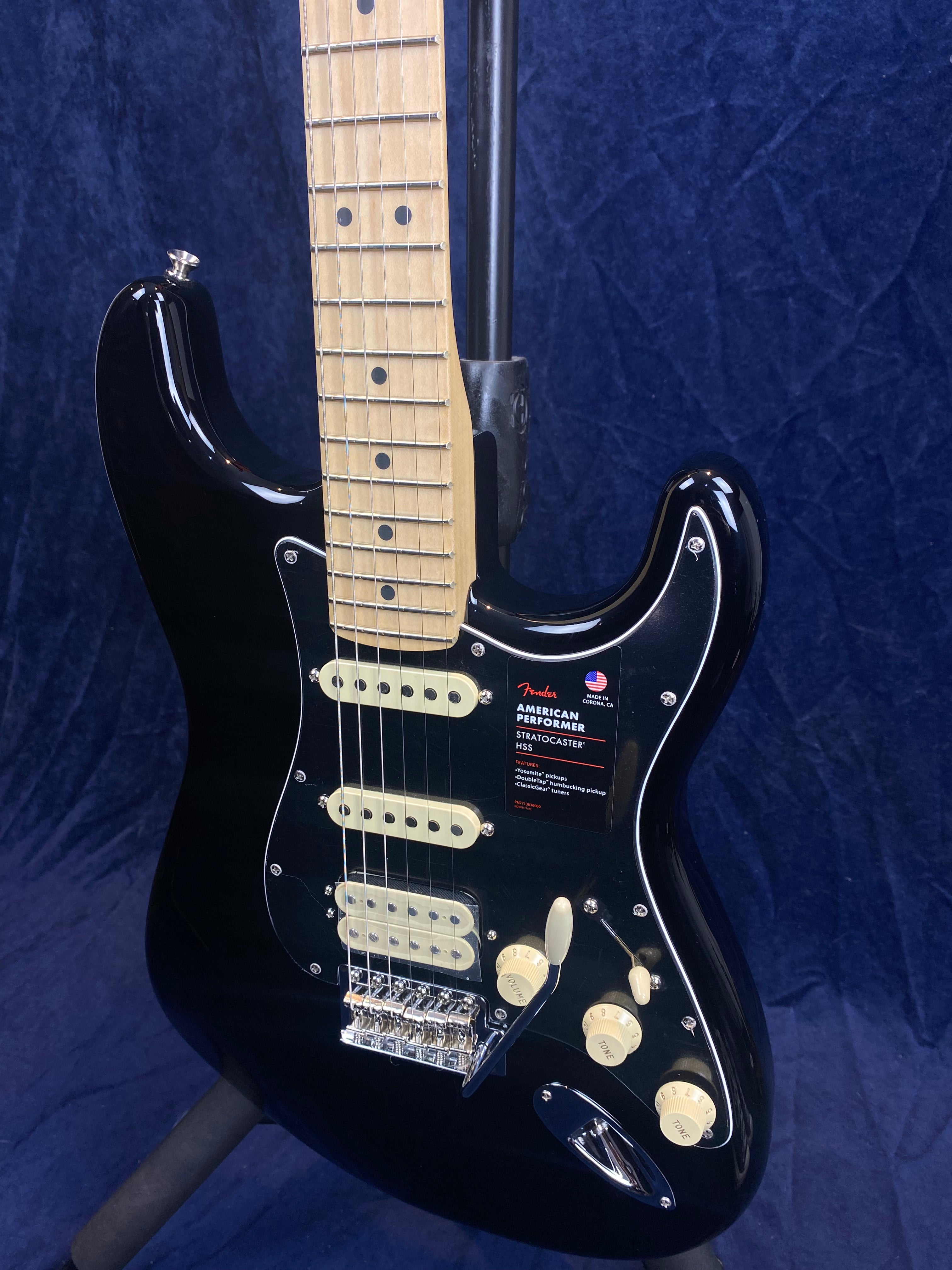 Black Fender American Performer Stratocaster HSS electric guitar with a light maple neck, cream-colored pickups, knobs, and a whammy bar.